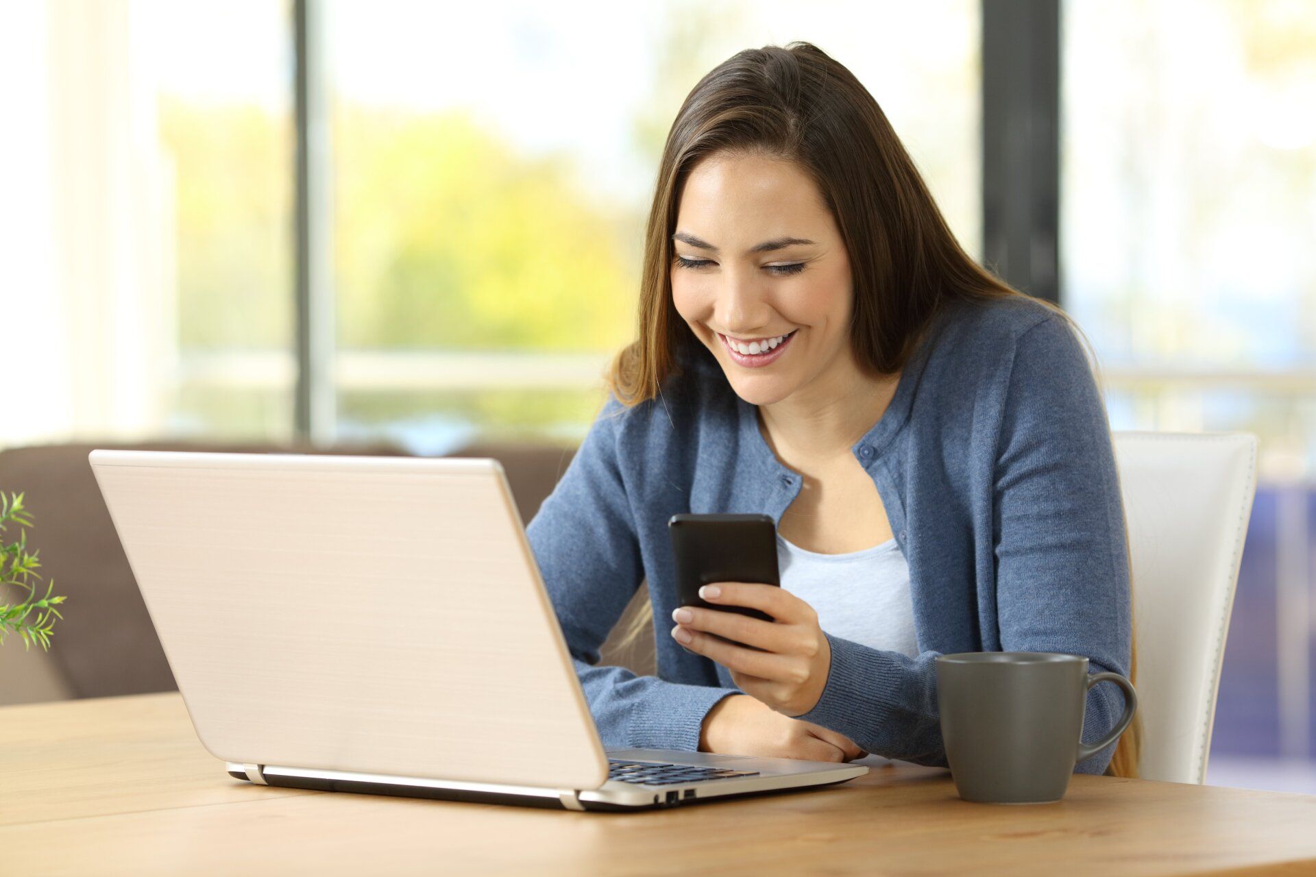 Woman interacting with TikTok Ads on mobile phone and laptop.