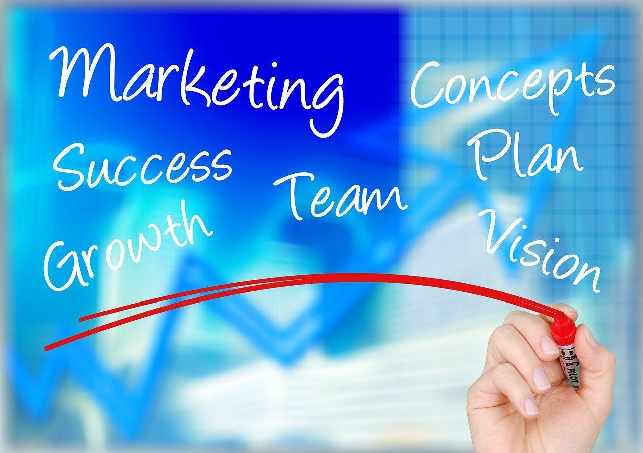 Hand with red marker underlining Marketing, Growth, Team, Plan on a blue background with charts.