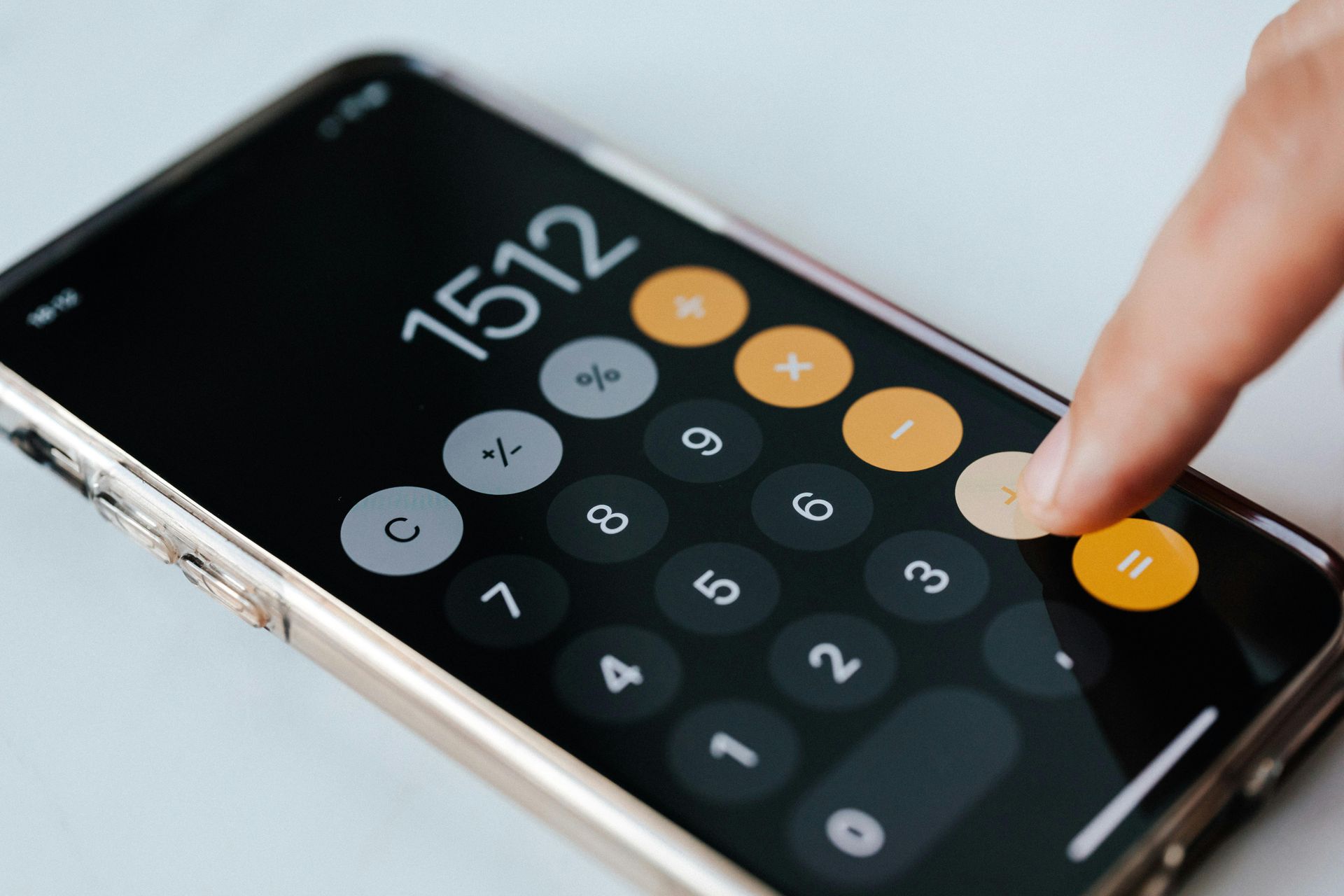 A person is using a calculator on a cell phone.