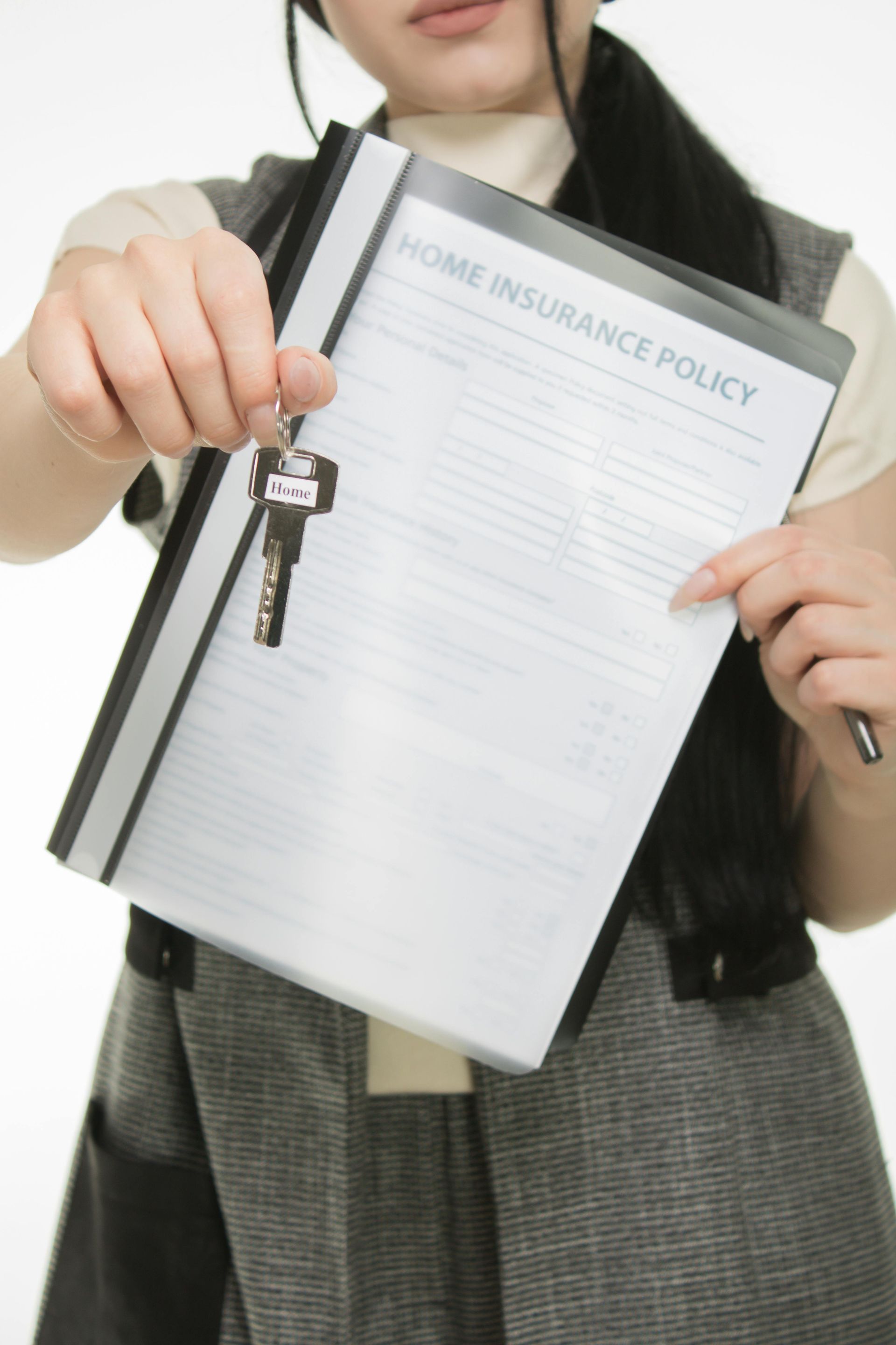 A woman is holding a home insurance policy and keys
