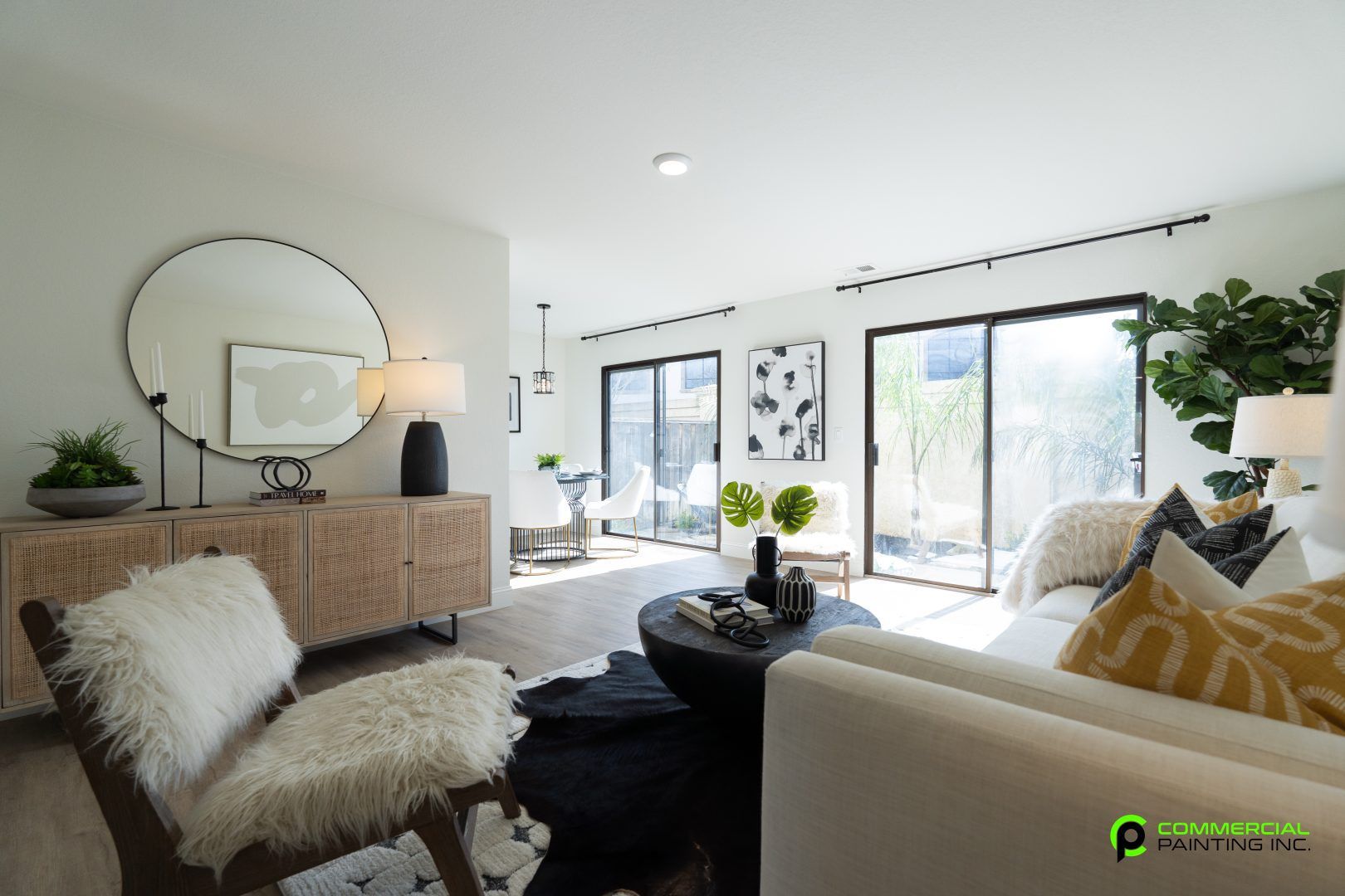 A living room with a couch , chair , table and mirror.