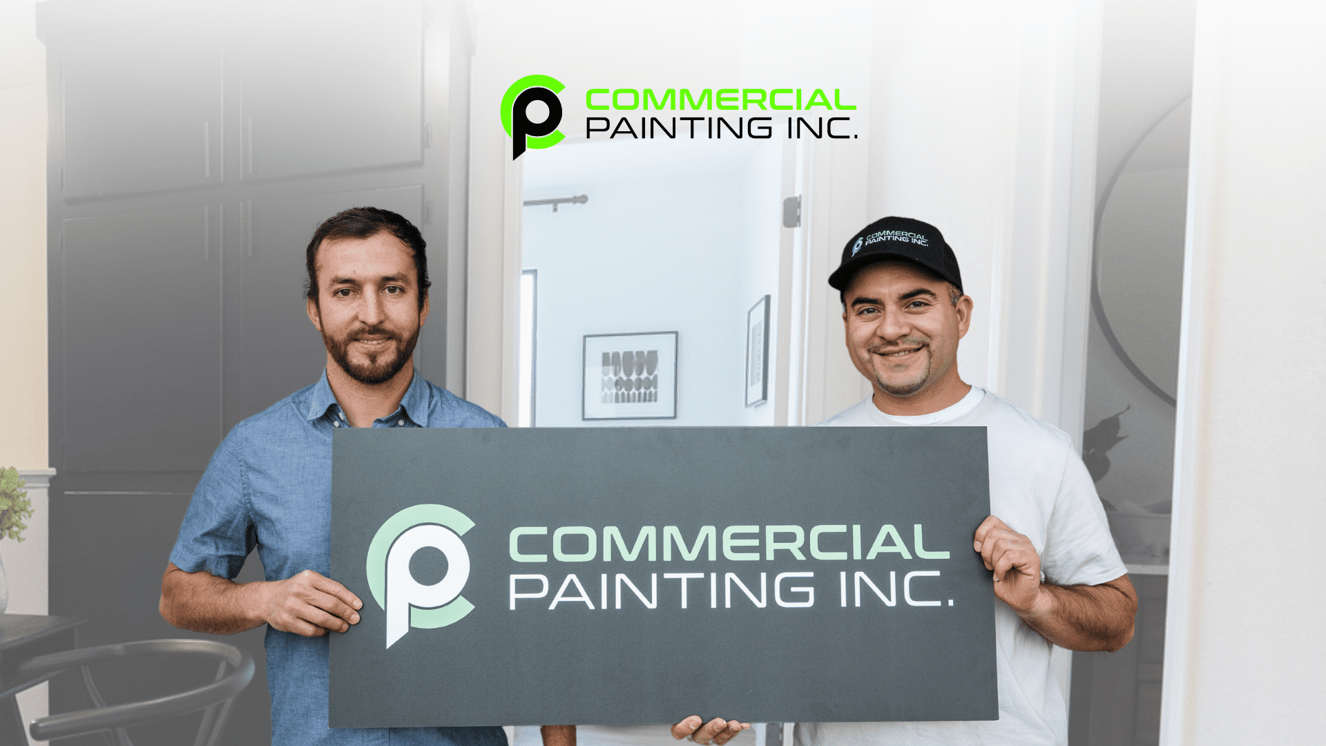 Two men are holding a sign for commercial painting inc.
