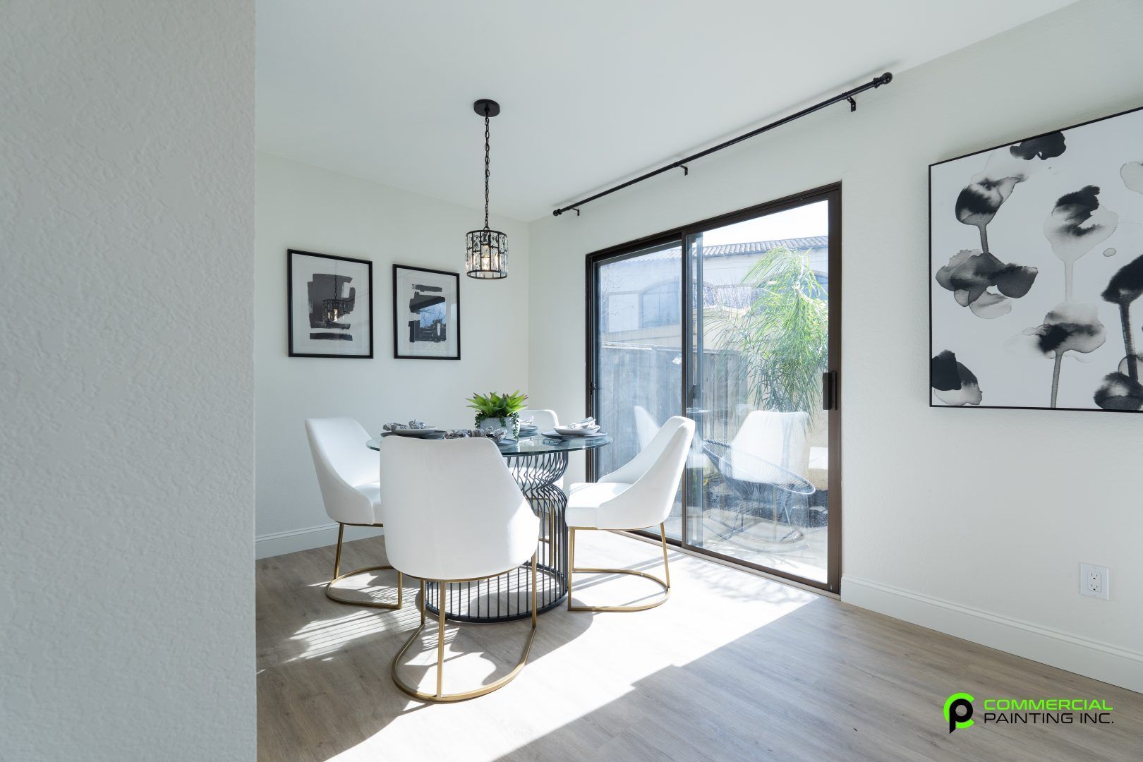 A dining room with a table and chairs and a sliding glass door.