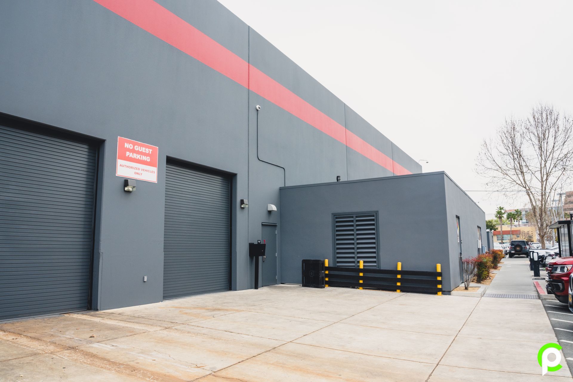 A large gray building with a red stripe on the side.