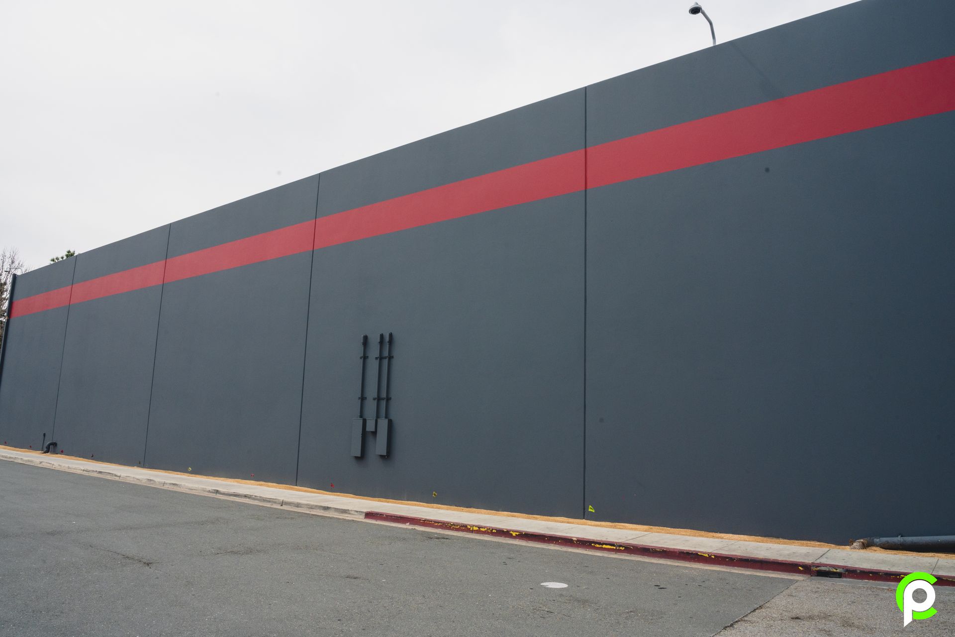 A large gray wall with a red stripe on it
