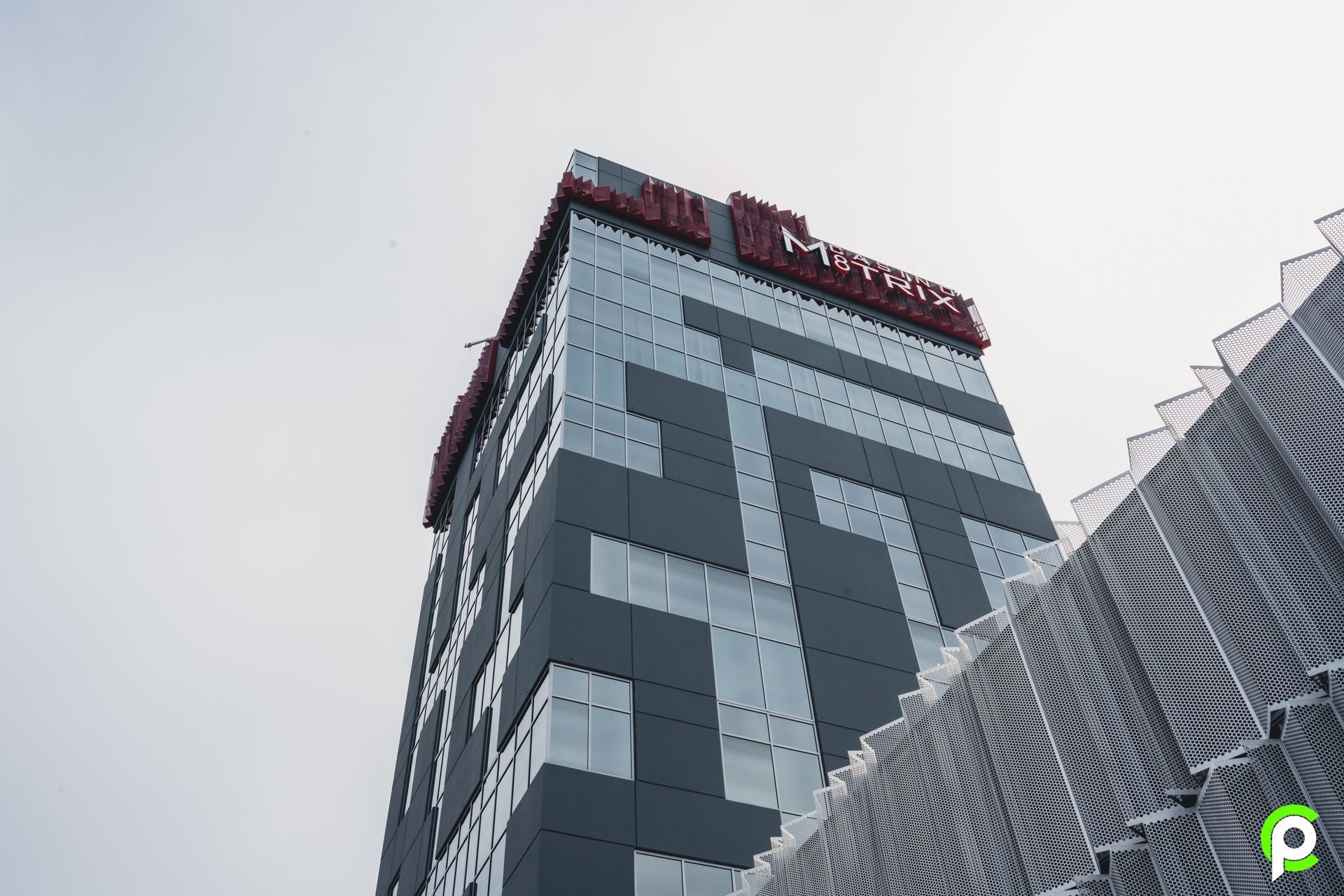 Looking up at a tall building with the letter p on it.