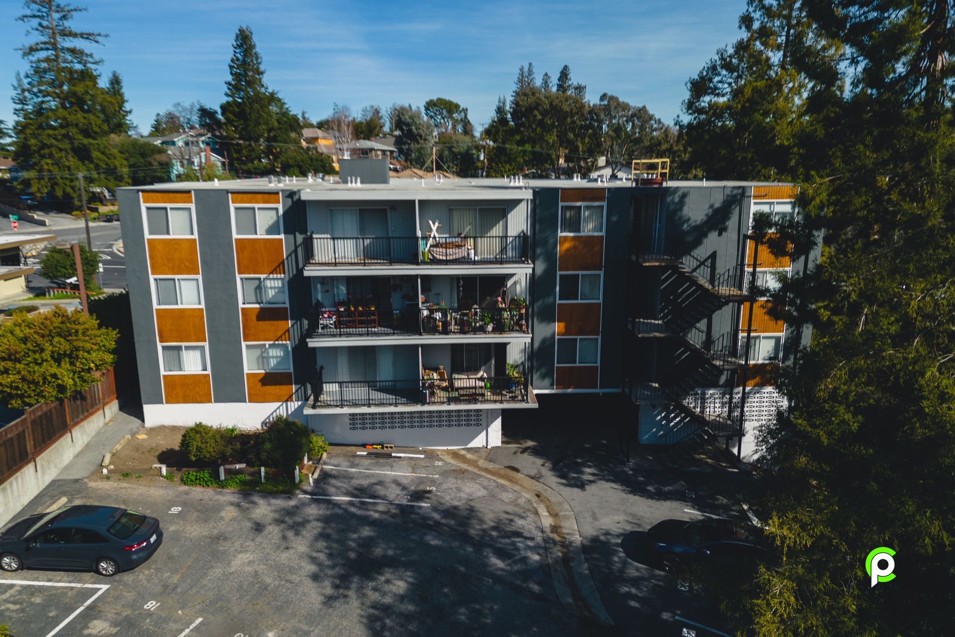 An aerial view of a building with cars parked in front of it