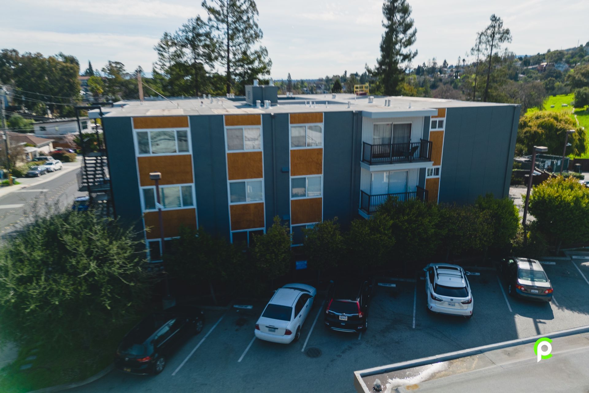 An aerial view of a building with cars parked in front of it