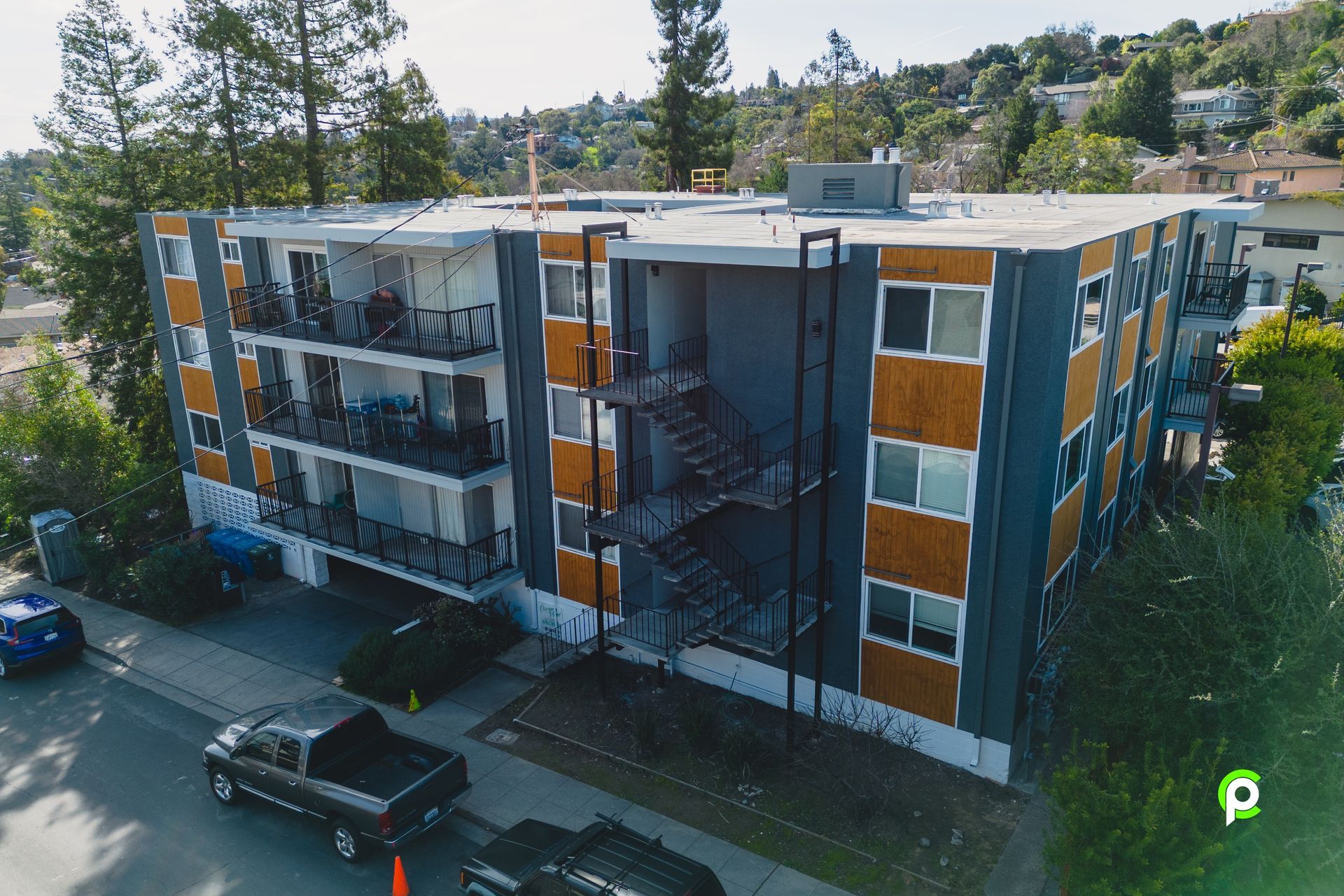 An aerial view of a large apartment building with a truck parked in front of it