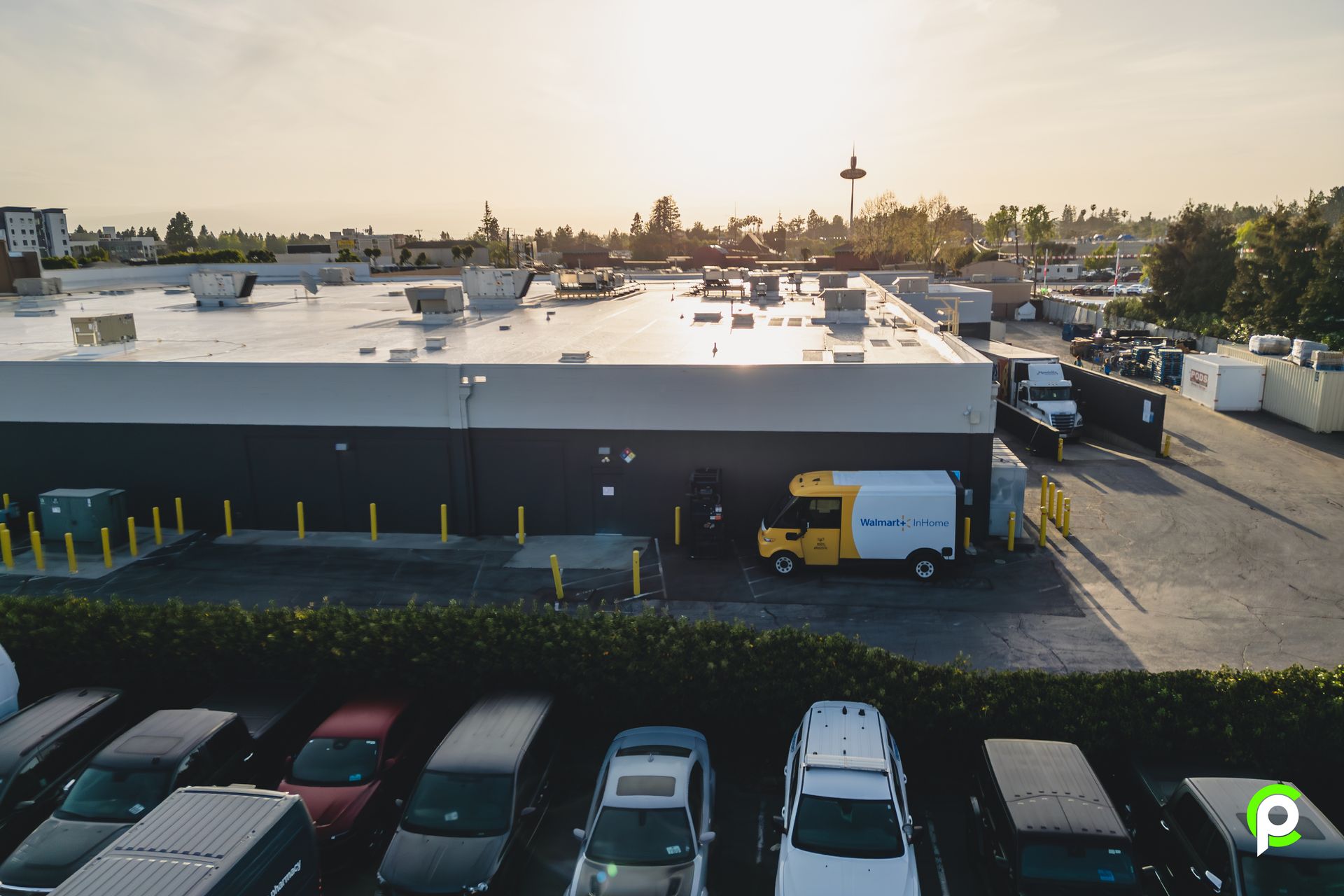 An aerial view of a parking lot with a building in the background