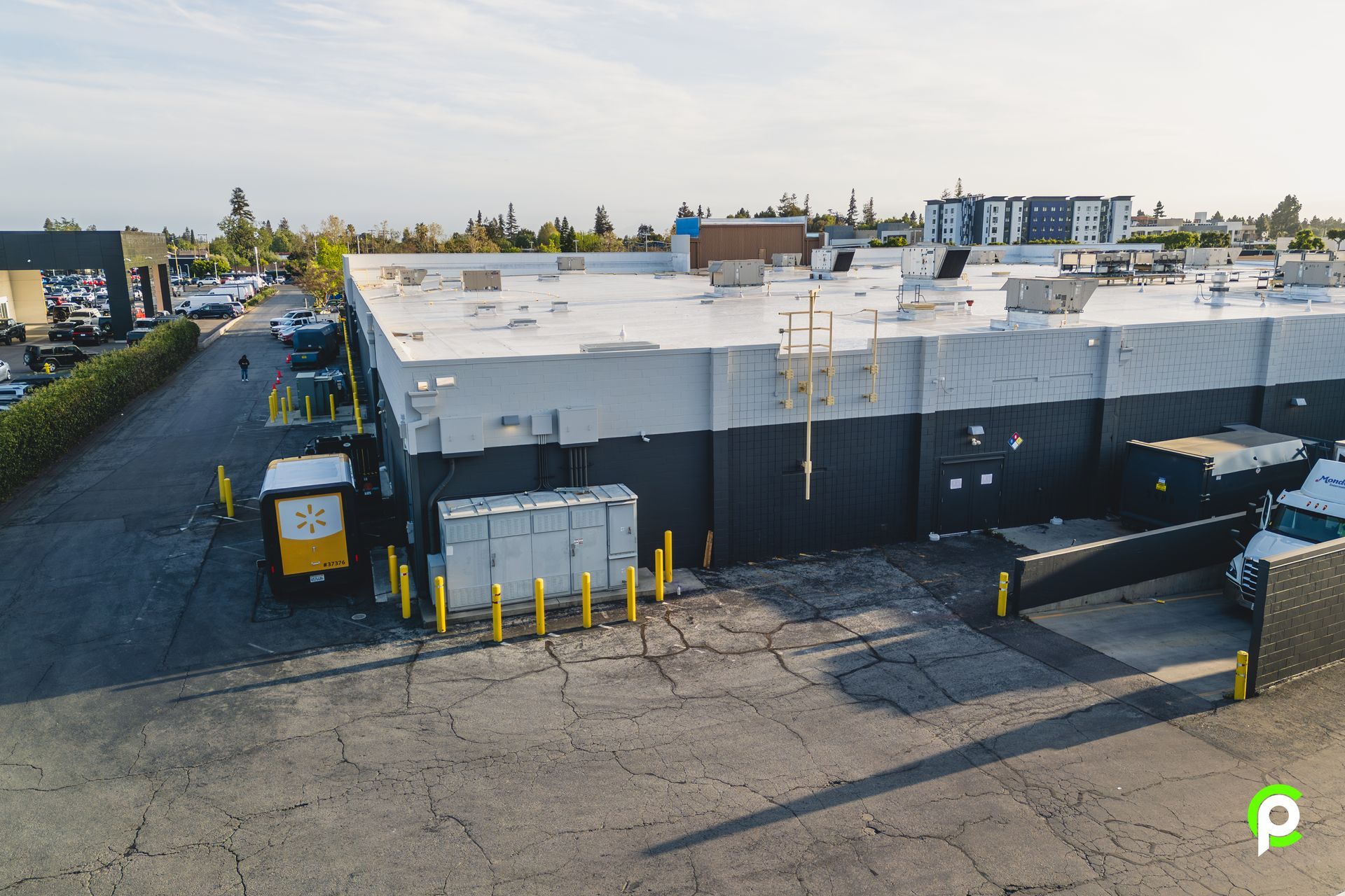 An aerial view of a large building with a white roof