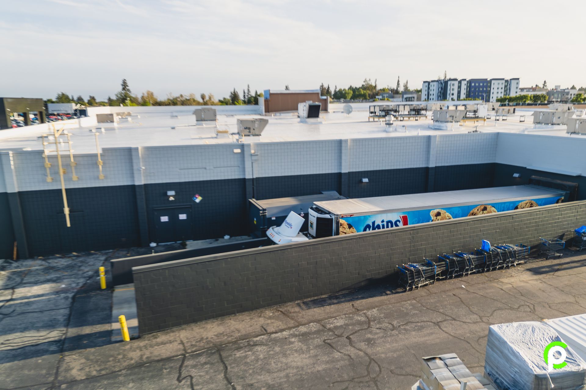 An aerial view of a large building with a white roof.