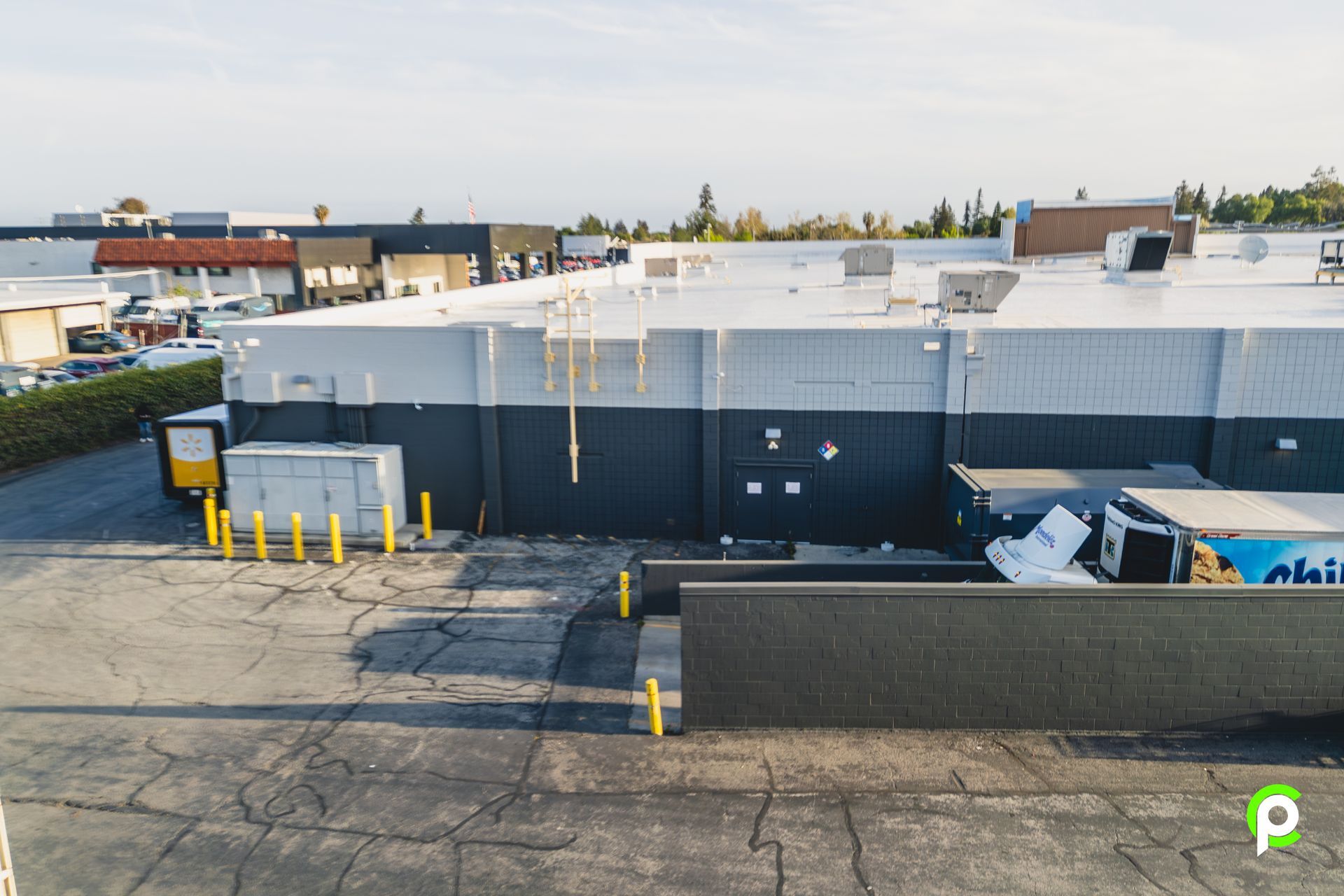 An aerial view of a large building with a white roof