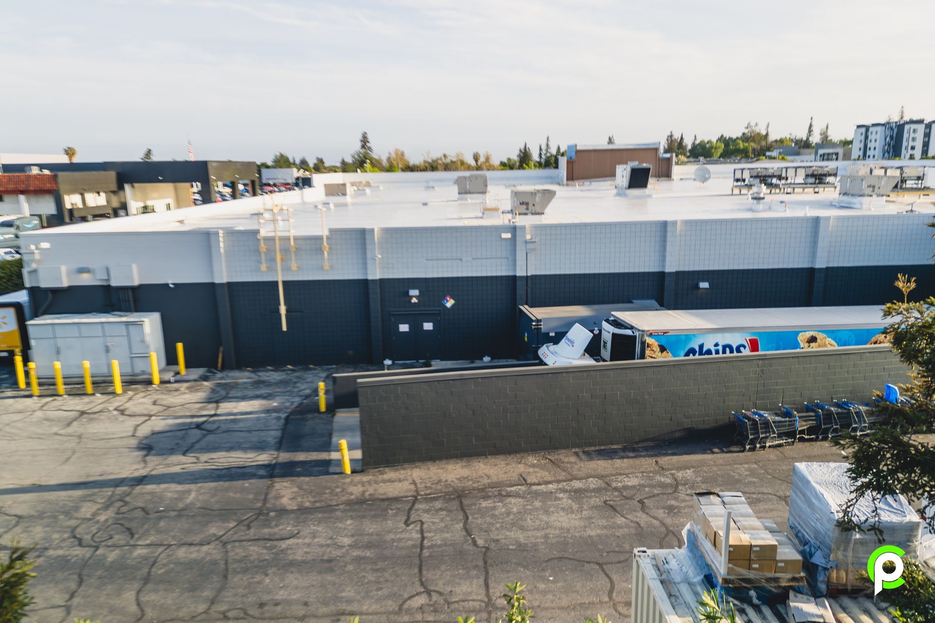 An aerial view of a large building with a white roof