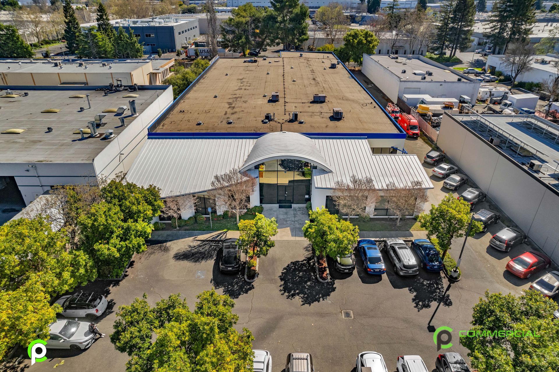 An aerial view of a large building with cars parked in front of it