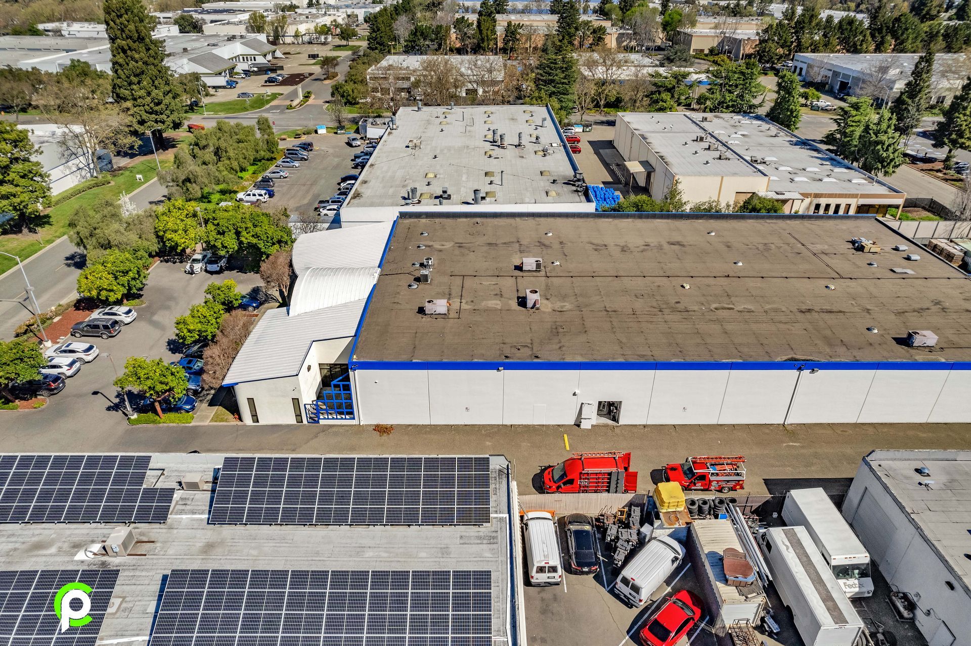 An aerial view of a large building with solar panels on the roof.