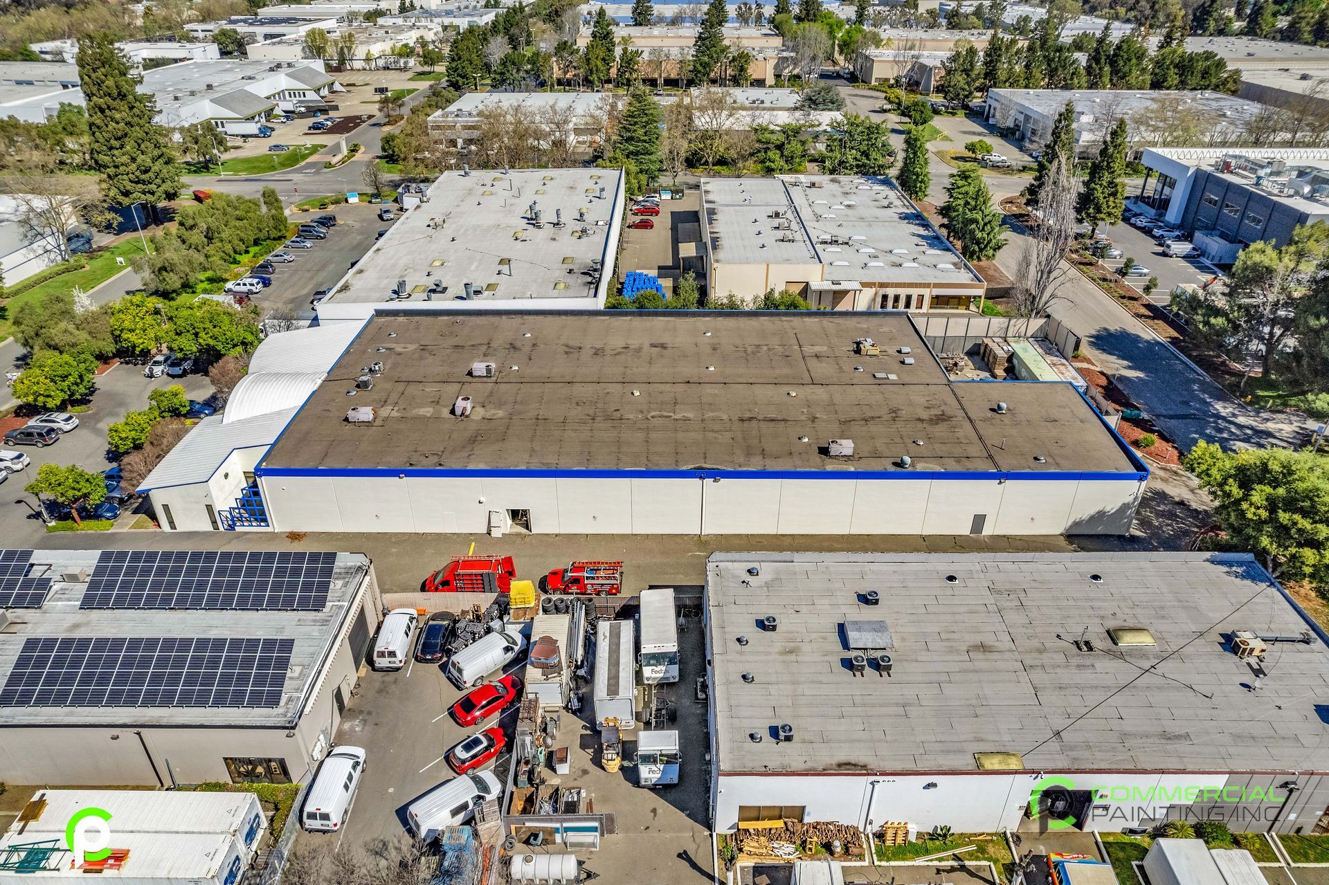 An aerial view of a warehouse with a lot of trucks parked in front of it.