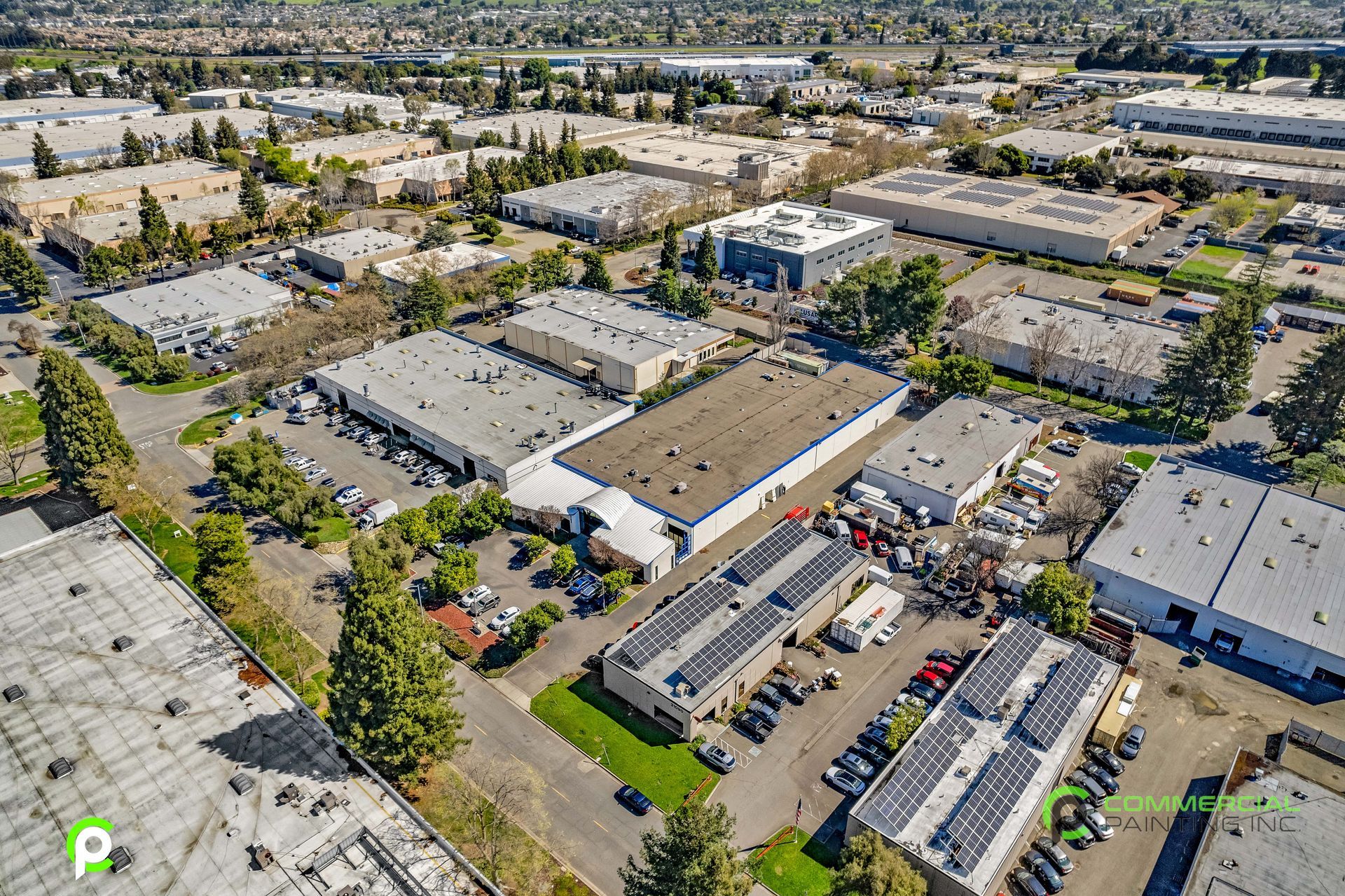 An aerial view of a large industrial area with lots of buildings and trees.