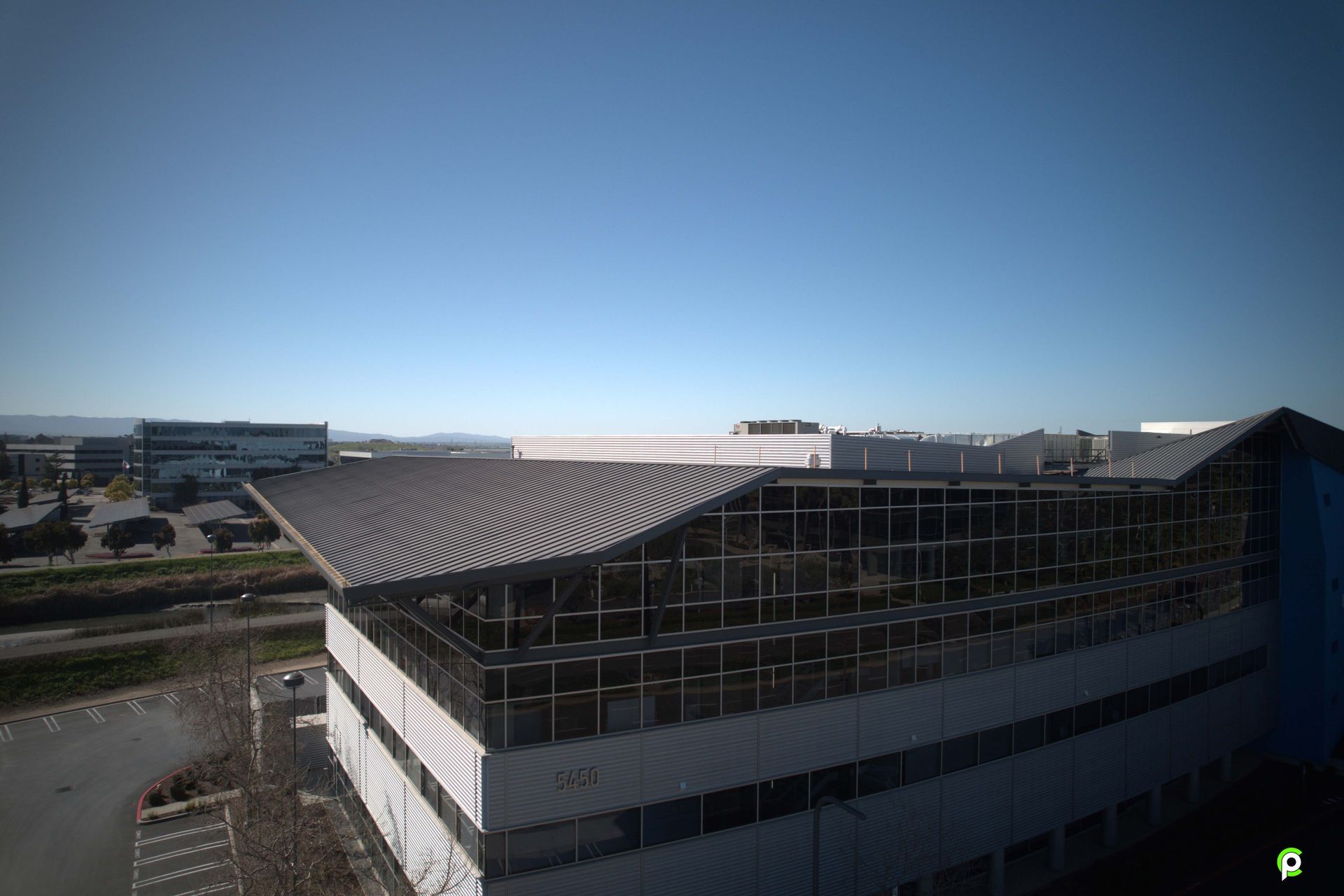 An aerial view of a large building under construction on a sunny day.