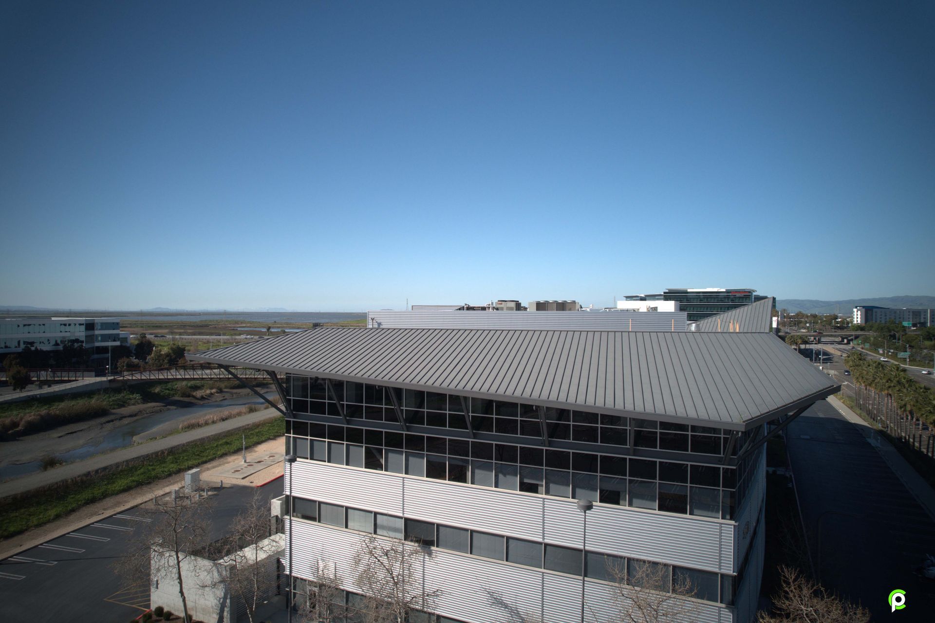 An aerial view of a large building with a gray roof.