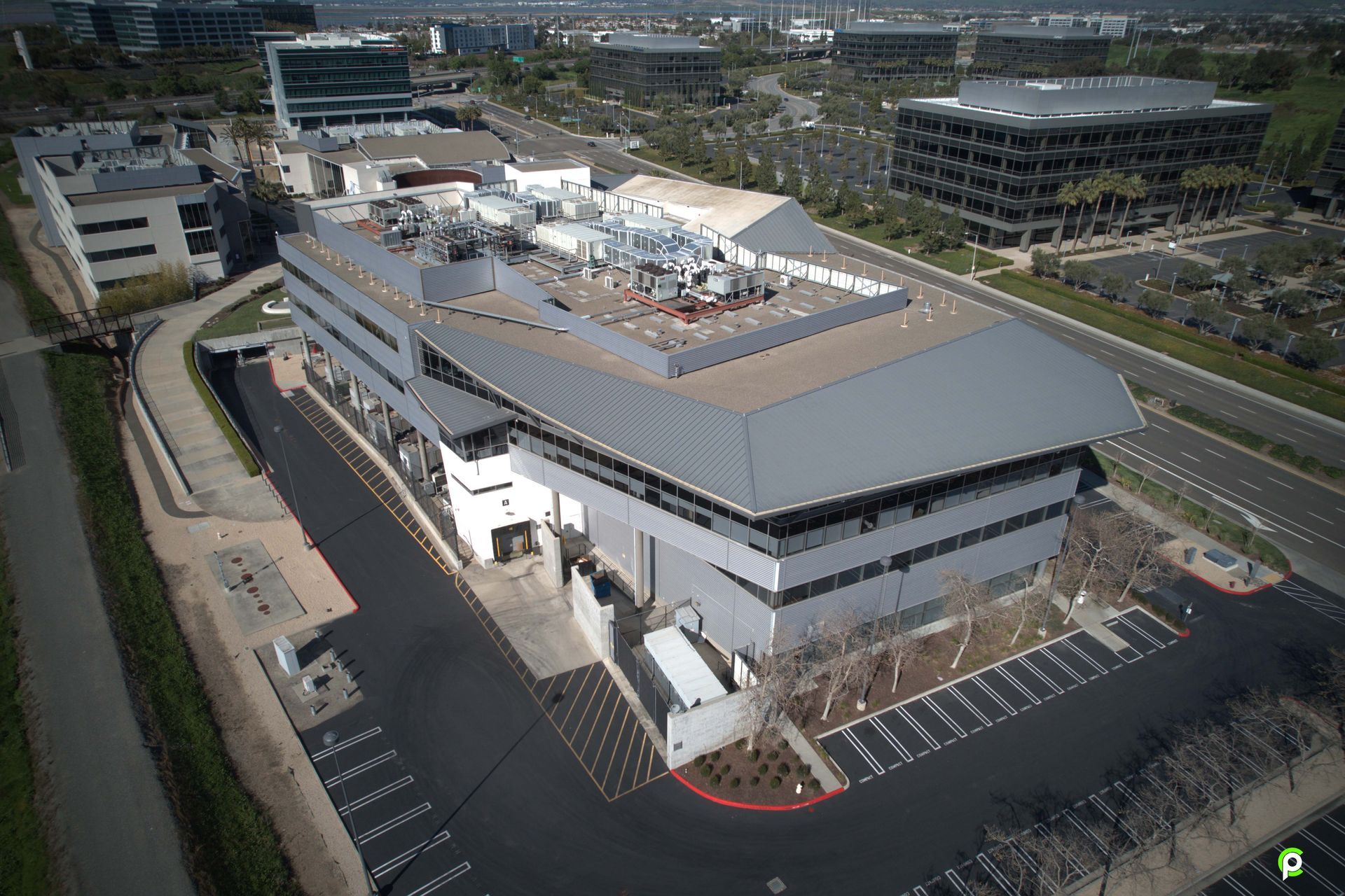 An aerial view of a large building with a parking lot in front of it.