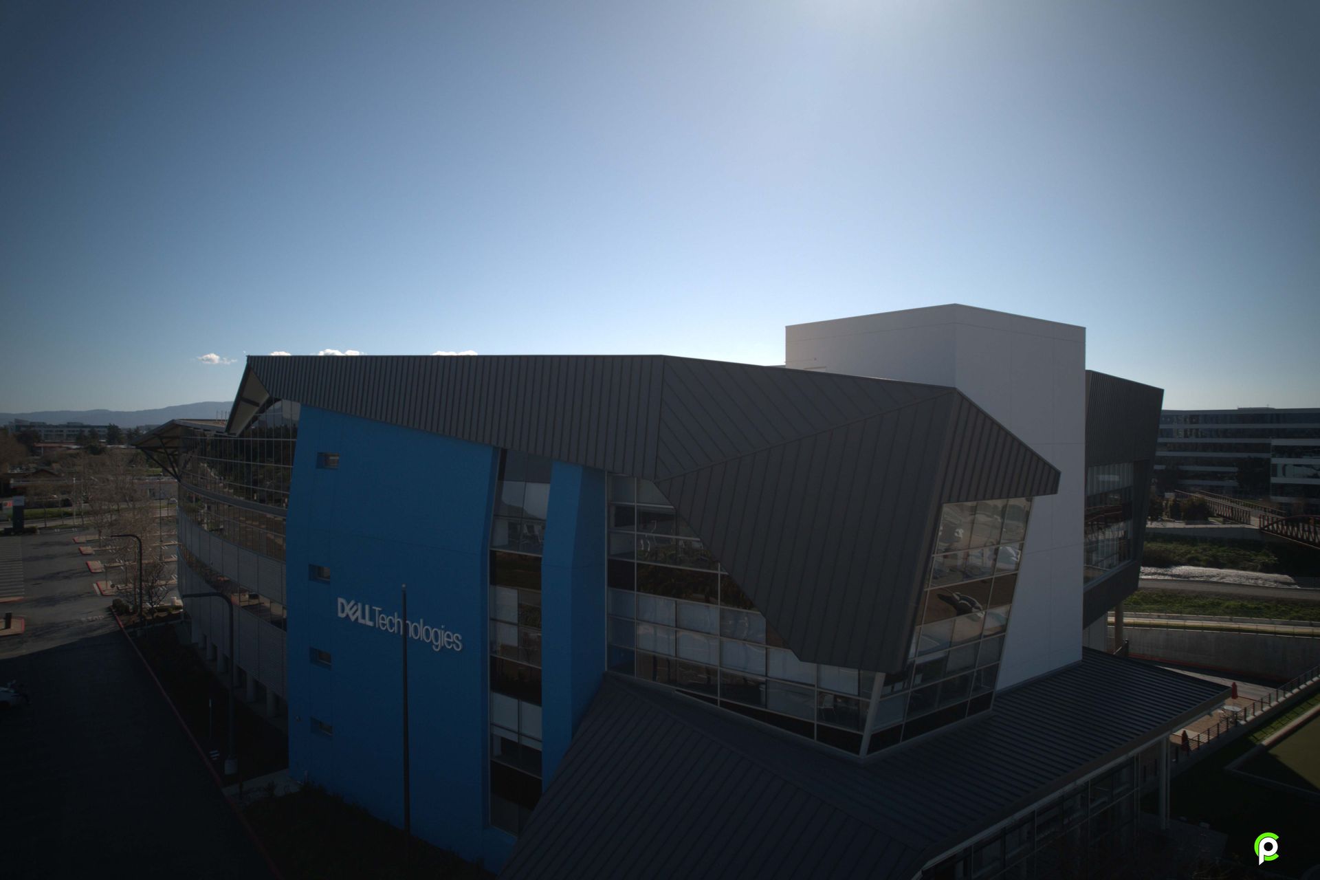 An aerial view of a large building with a blue and white roof.