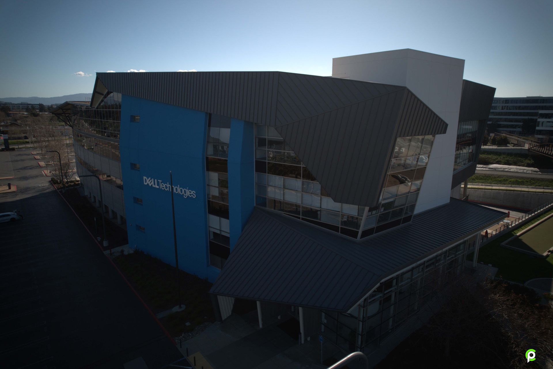 An aerial view of a large building with a blue and white facade