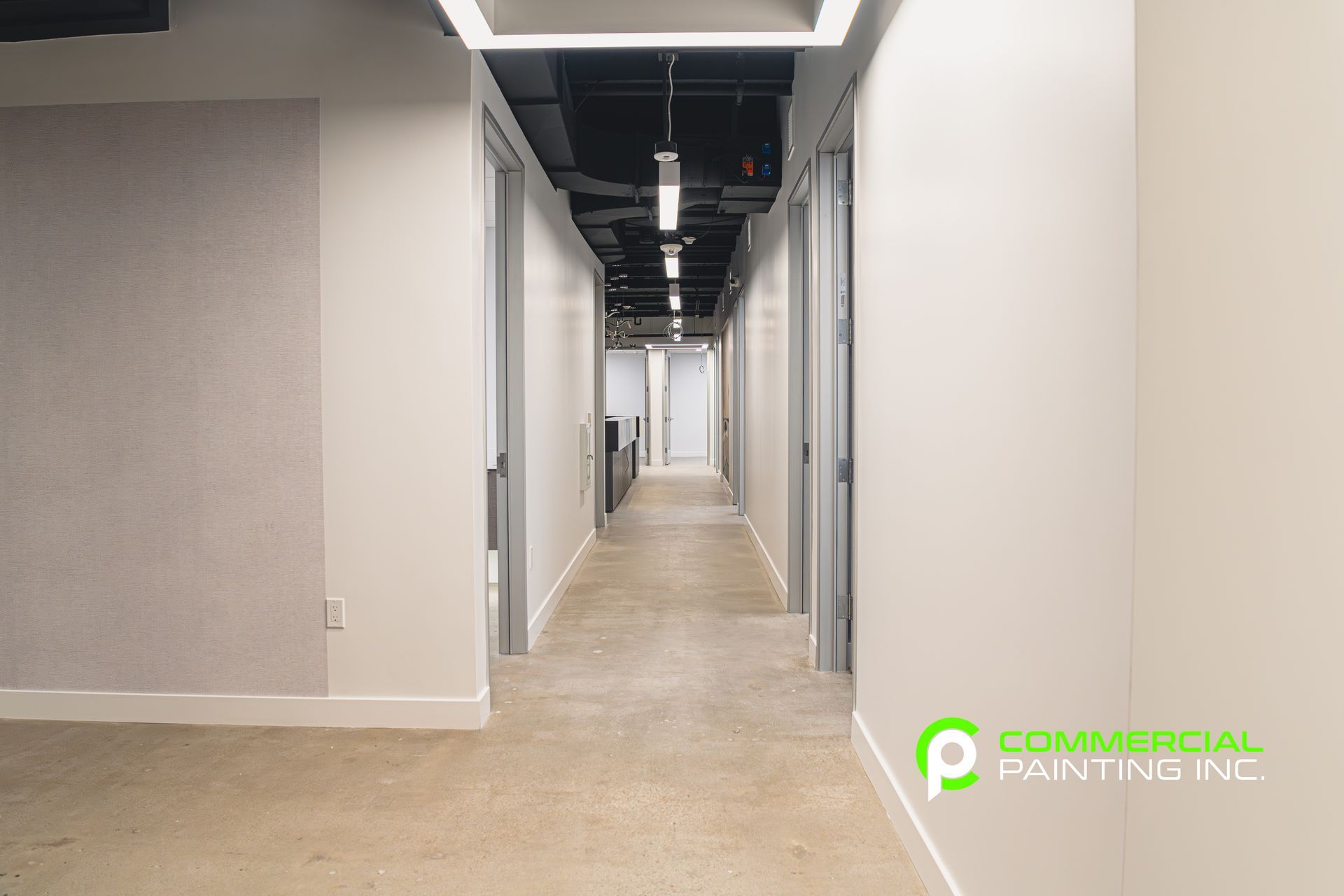 An empty hallway with white walls and a carpeted floor.
