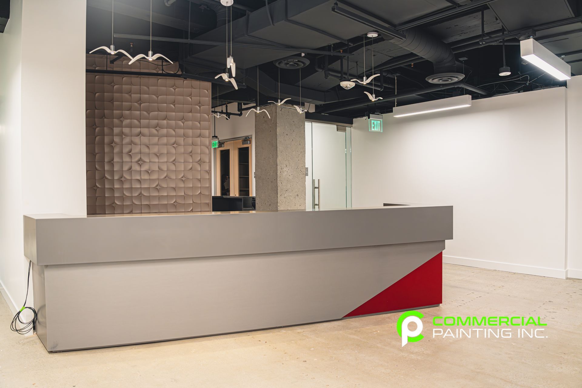 An empty office with a red and white reception desk.