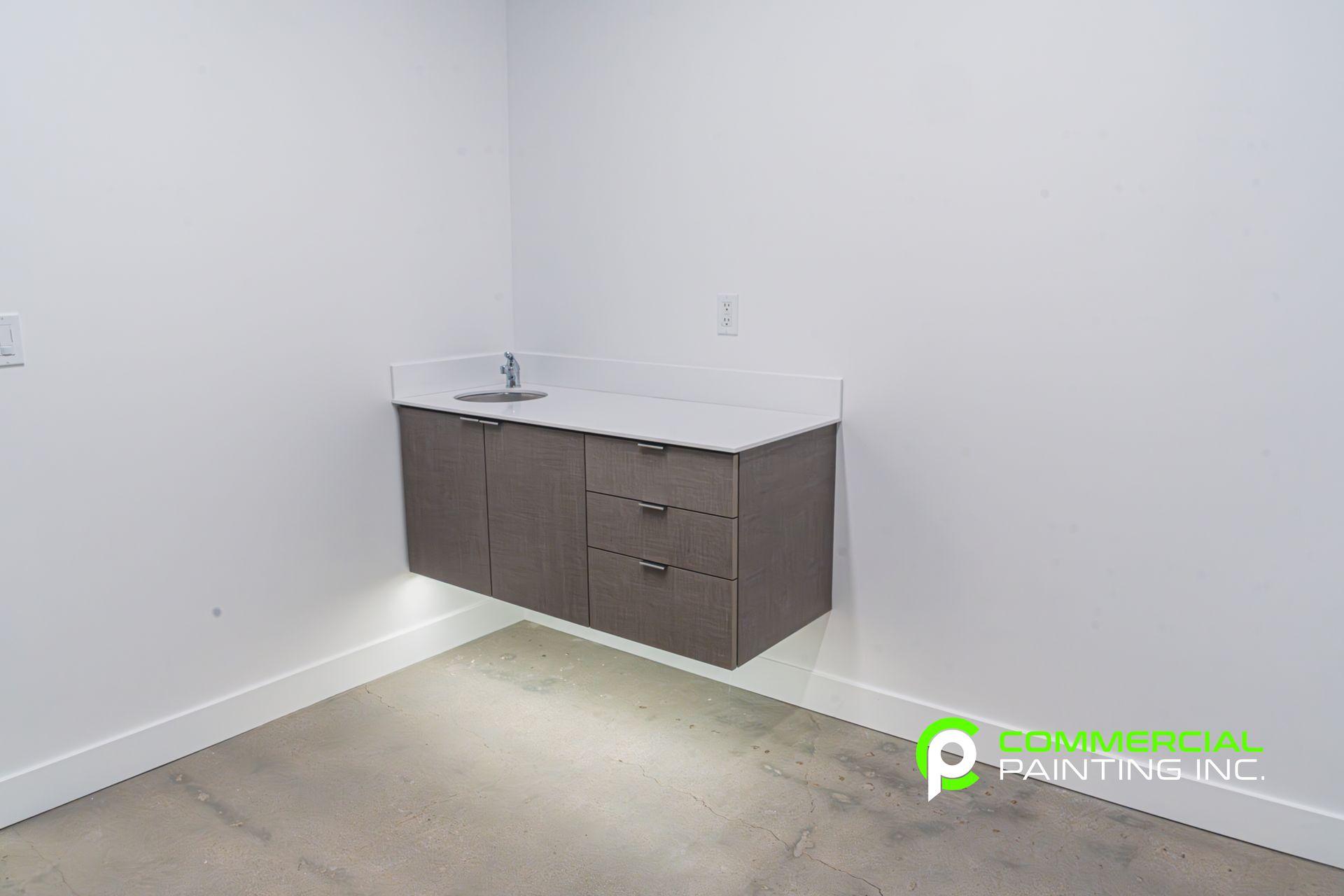 There is a sink in the corner of the room.