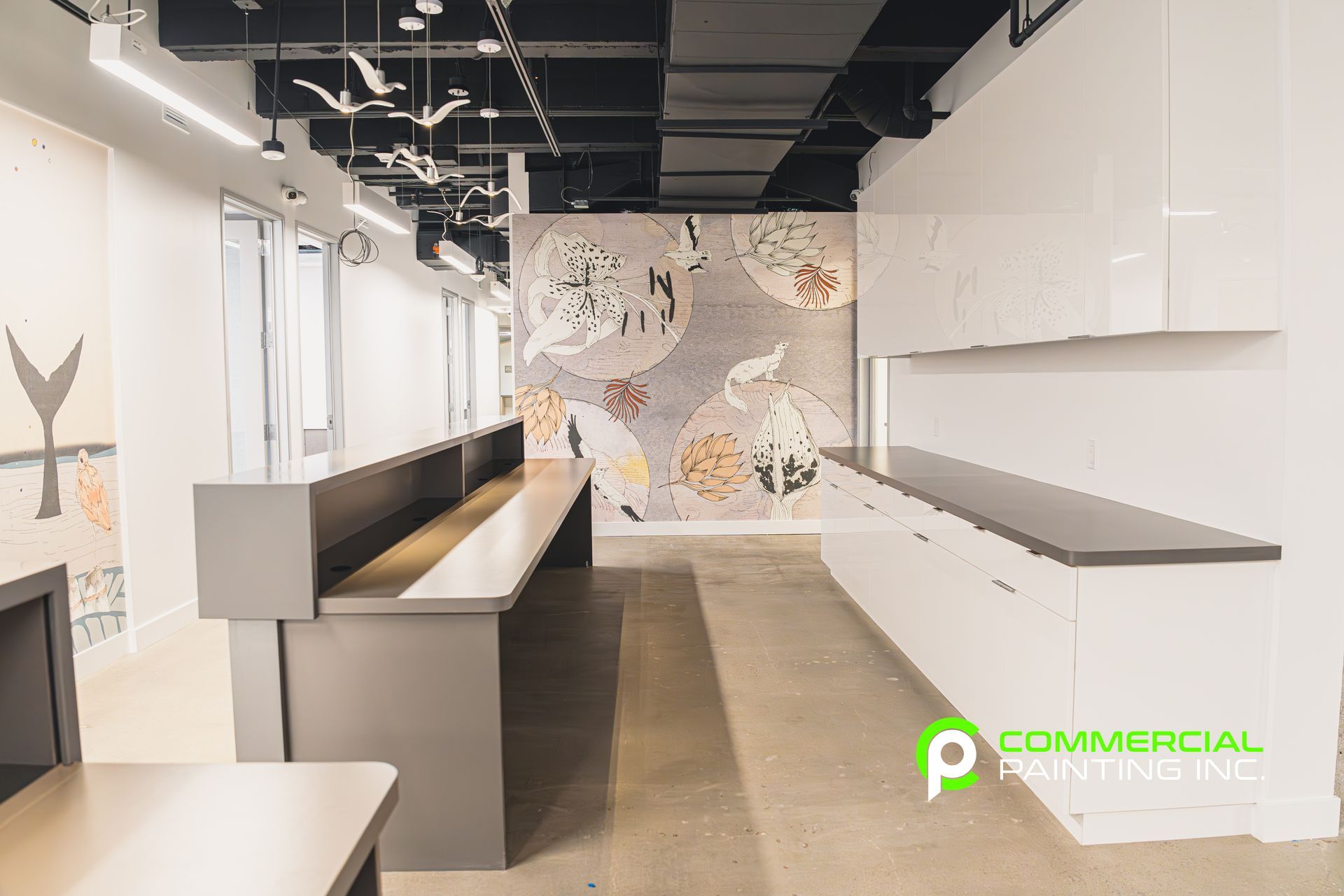 An empty office with a long counter and a large wall mural.