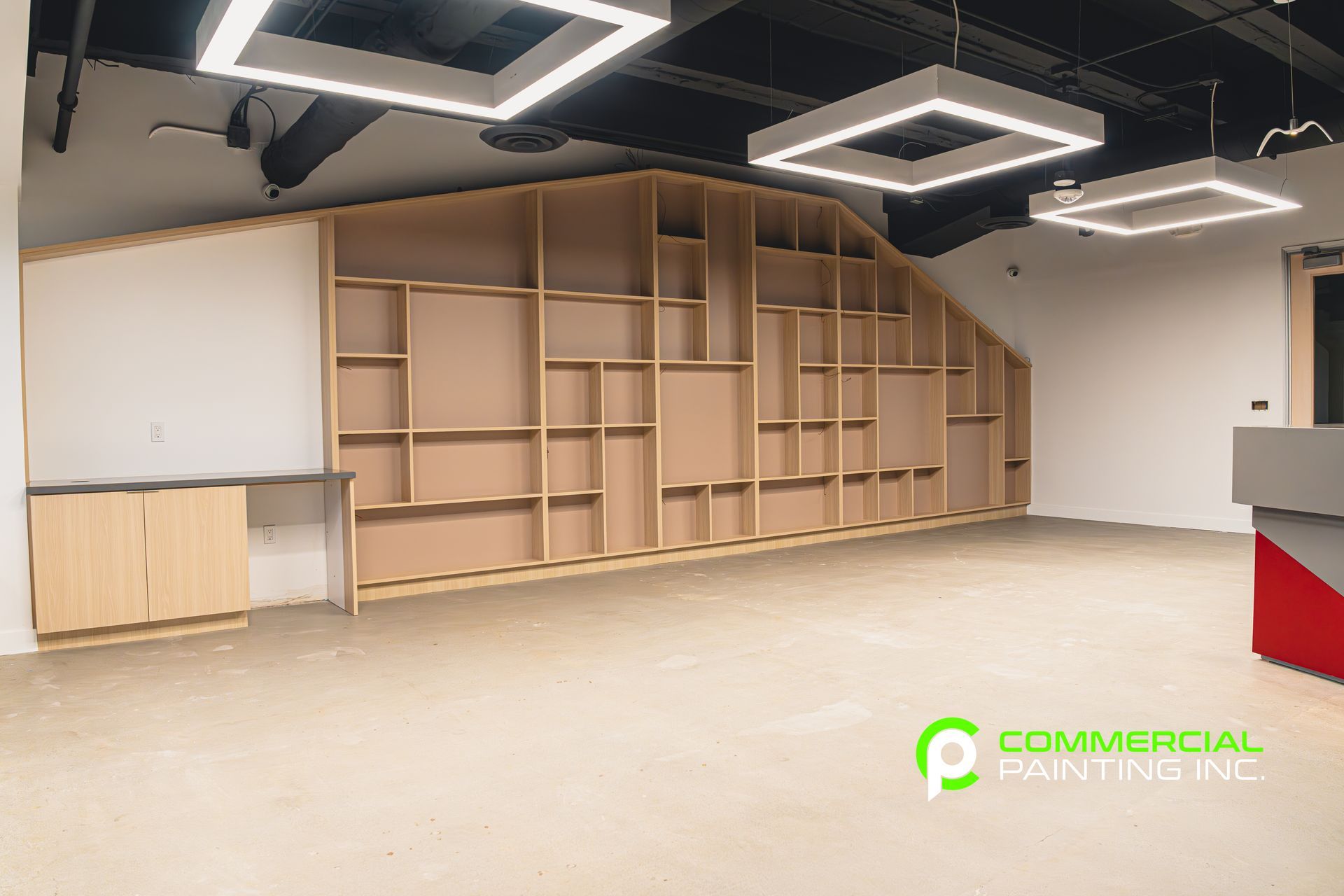 A large empty room with a lot of shelves and lights.