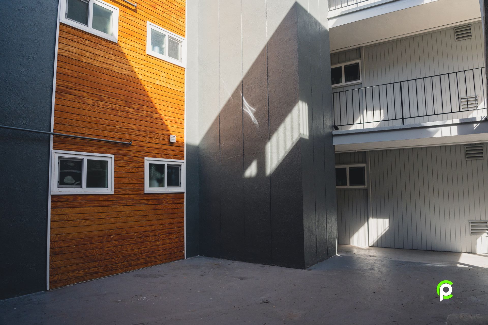 A building with a brick wall and a balcony on the side of it.