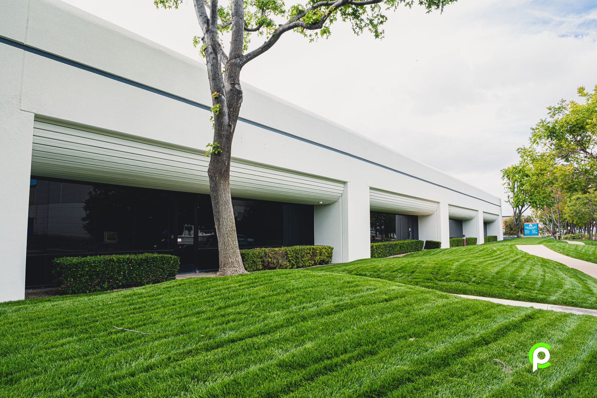 A large white building with a lush green lawn in front of it.