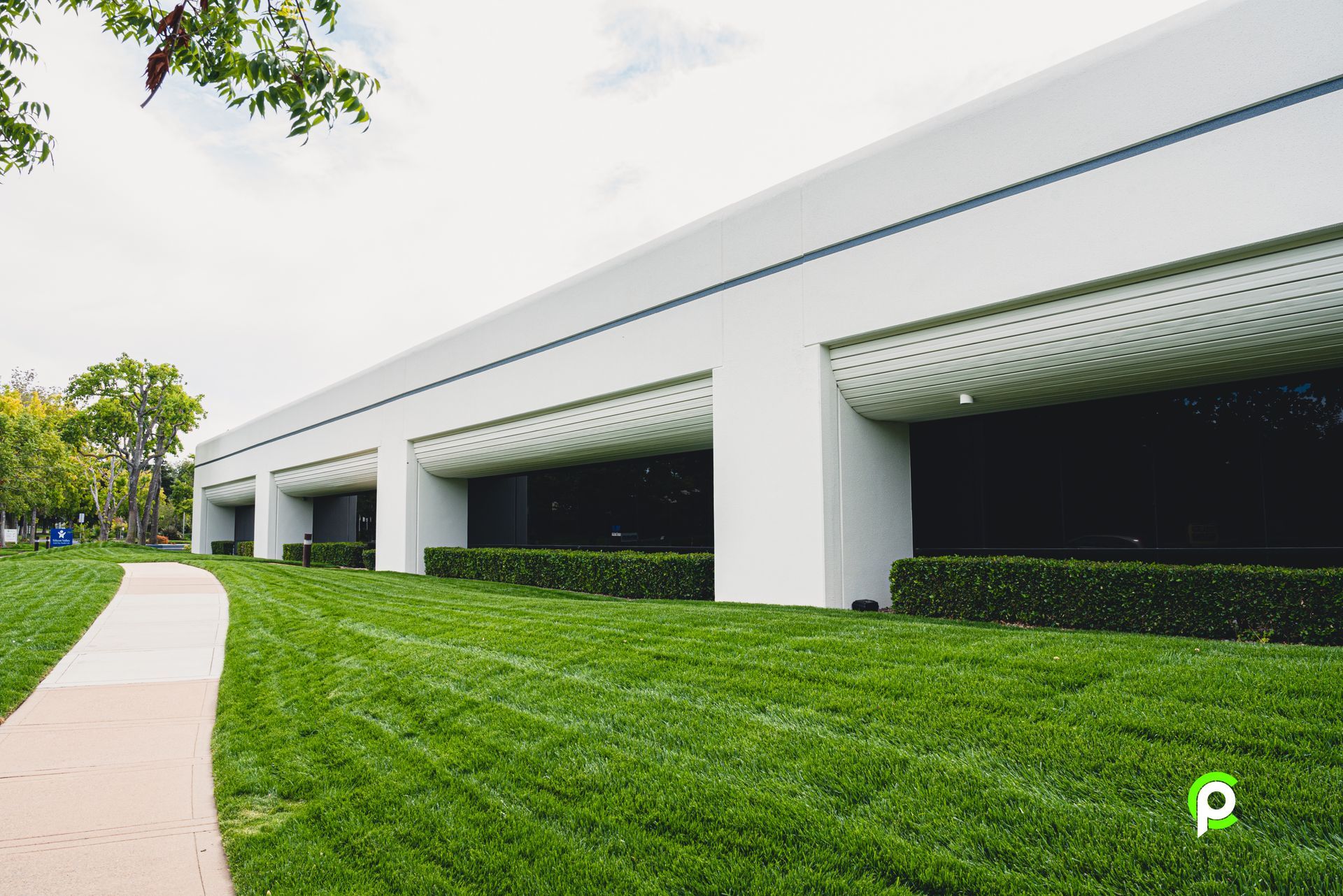 A large white building with a lush green lawn in front of it