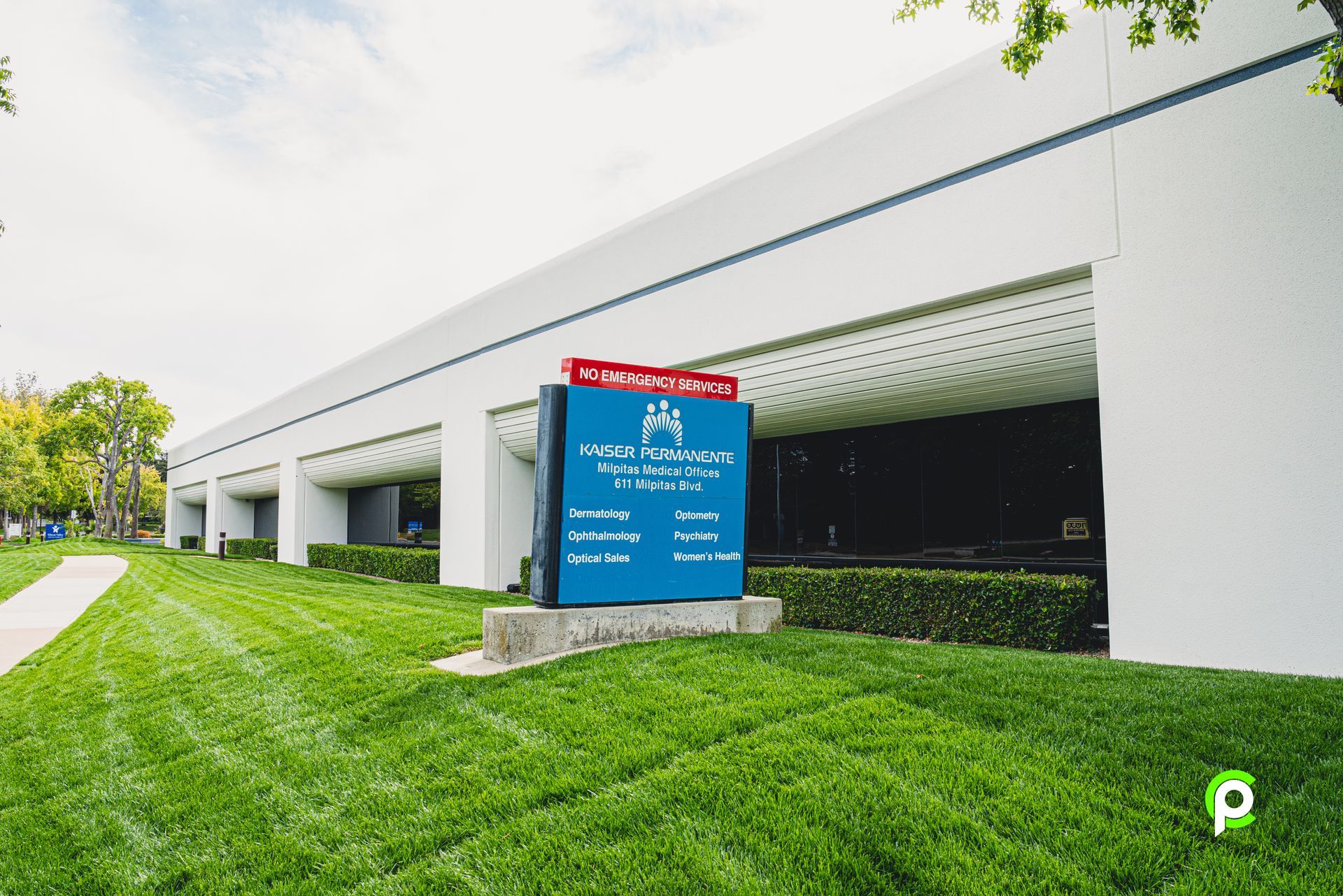 A large white building with a blue sign in front of it.
