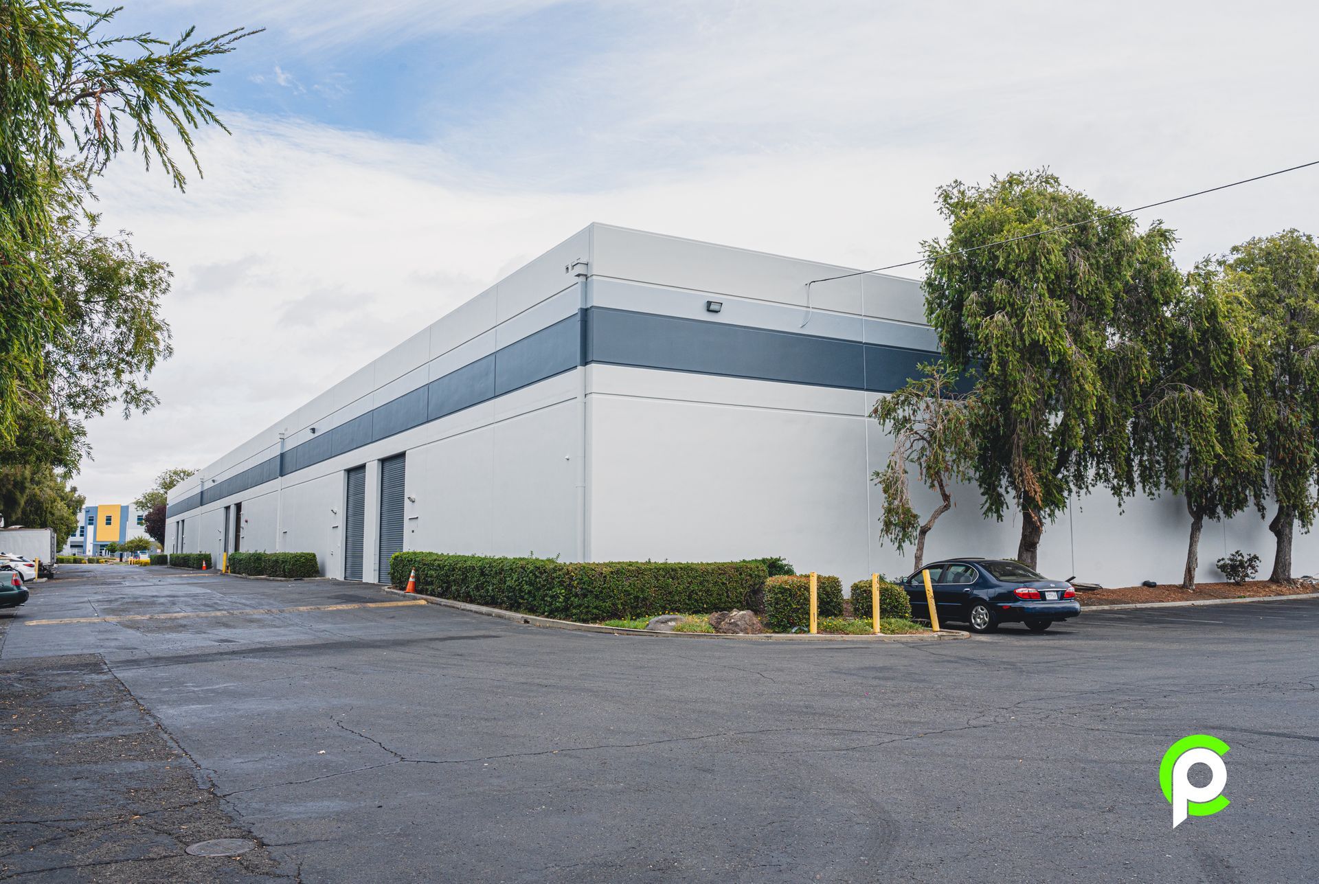 A large white building with a black car parked in front of it.