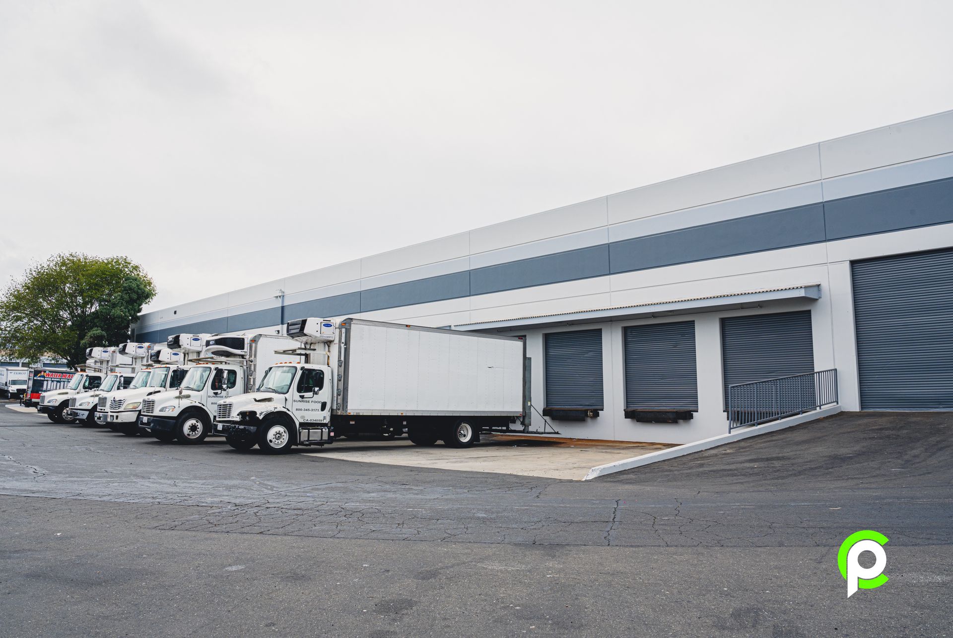 A large empty warehouse with white walls and orange poles.