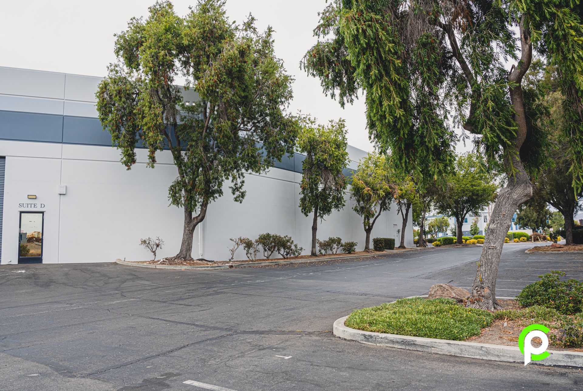 A white building with a parking lot in front of it