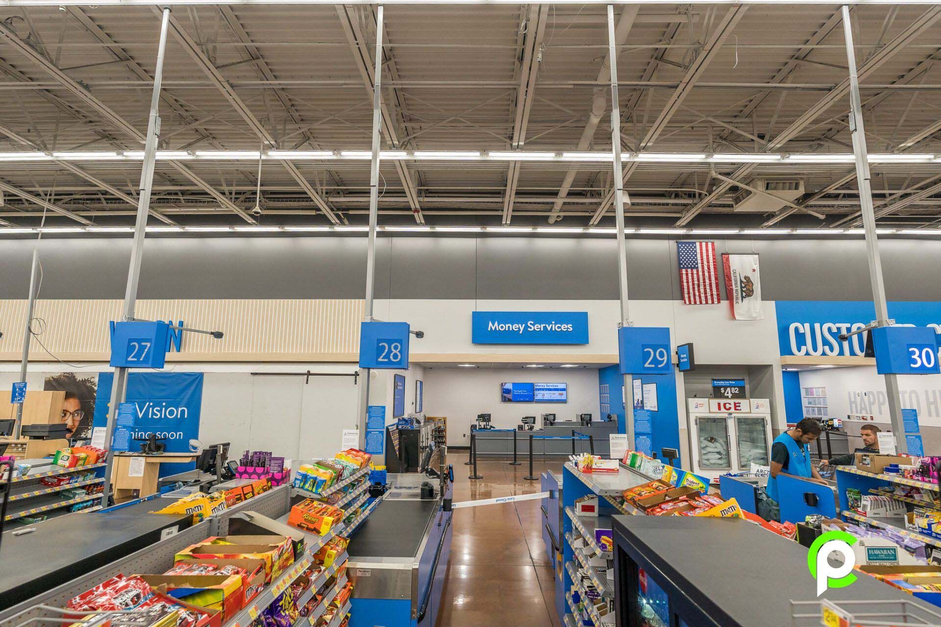 The inside of a walmart store with a cash register.