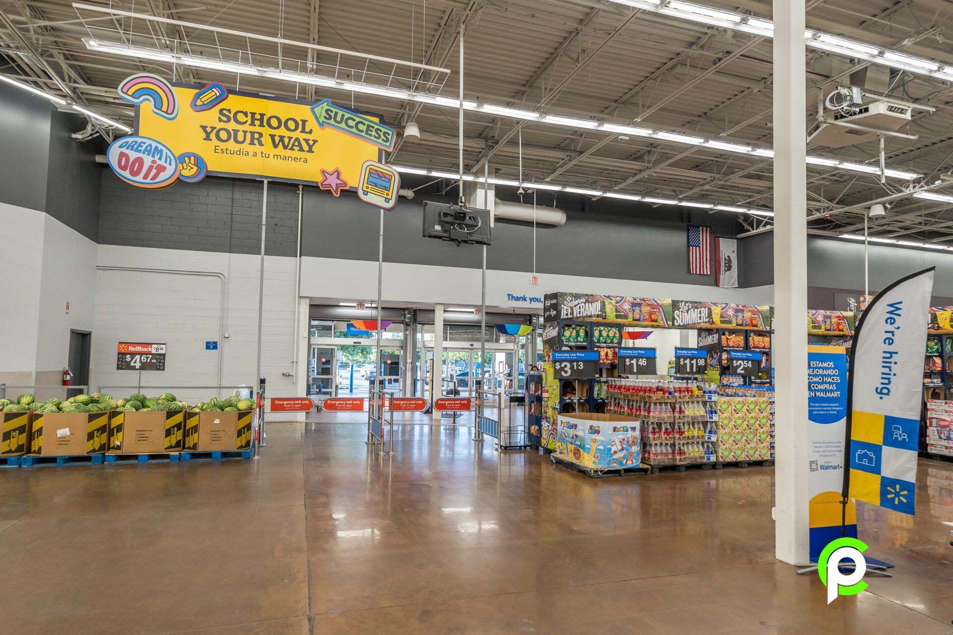 The inside of a walmart store with a sign that says `` school your way ''.