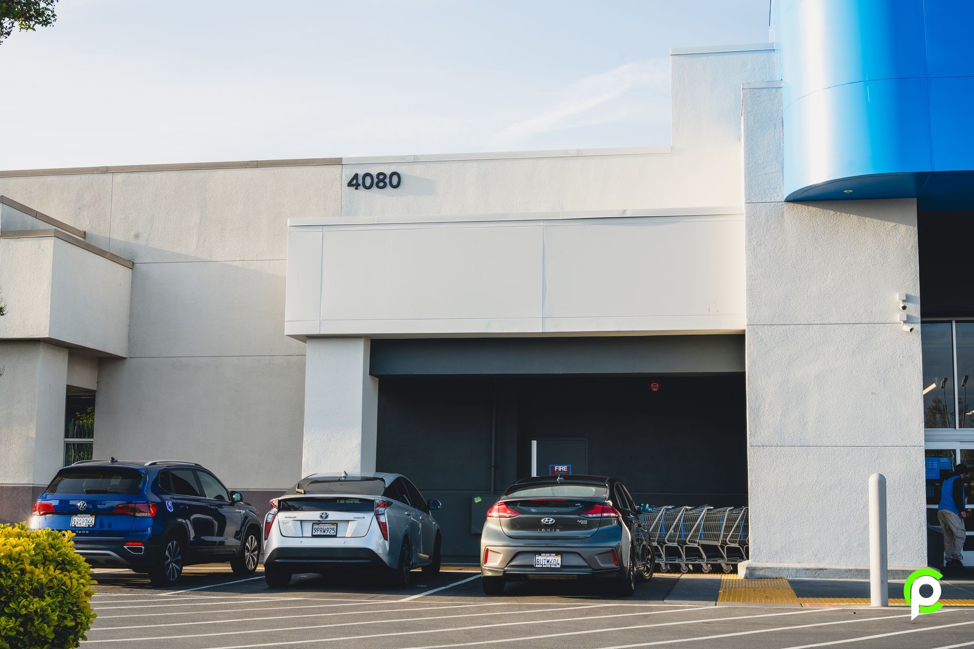 A couple of cars are parked in front of a building.