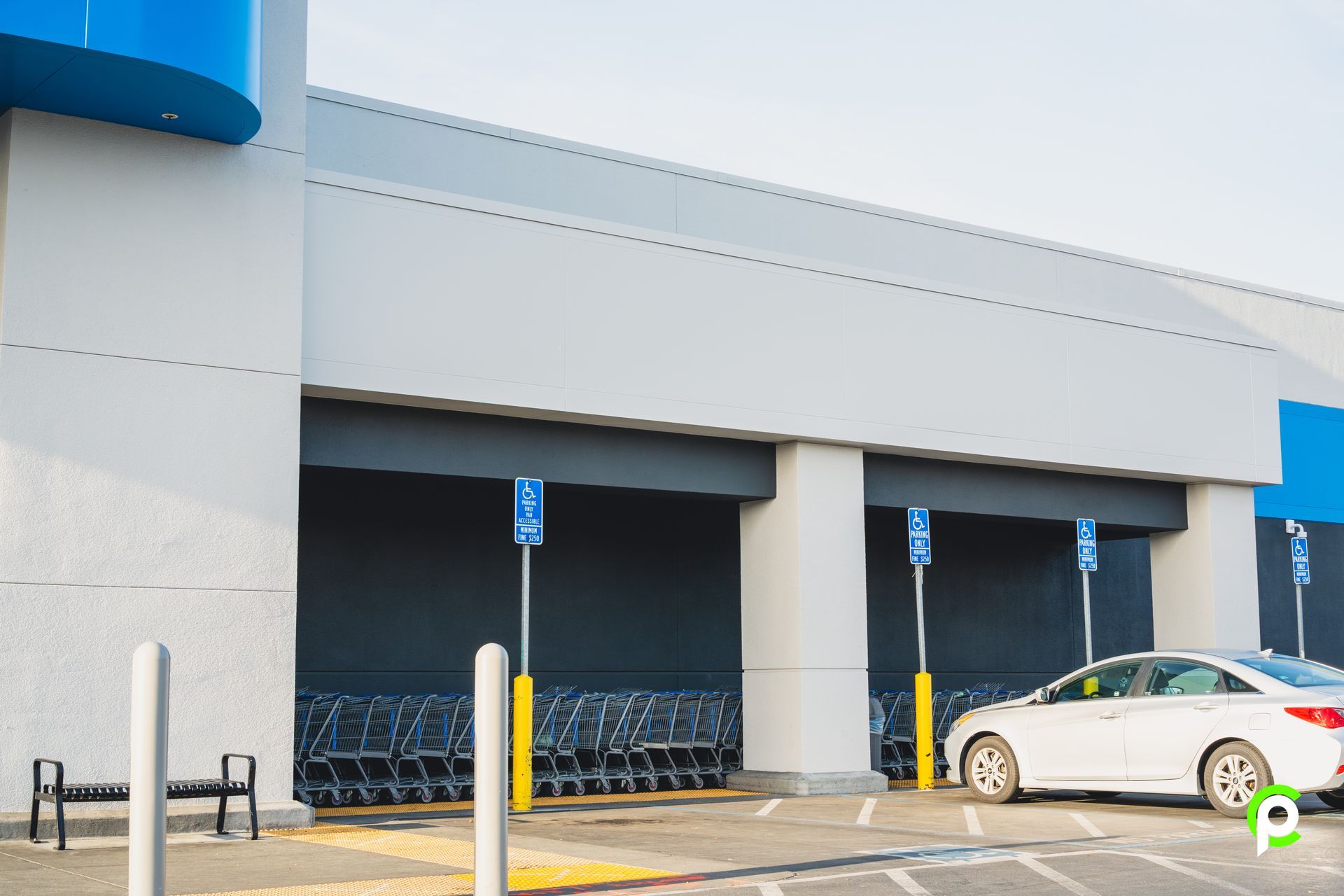 A white car is parked in front of a store.