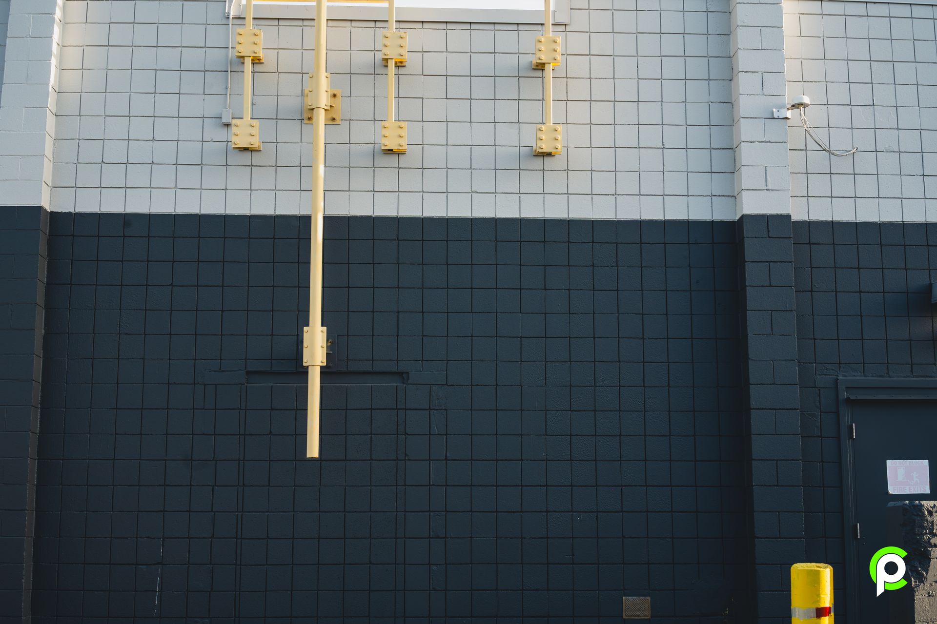 A black and white building with a yellow pipe on the side