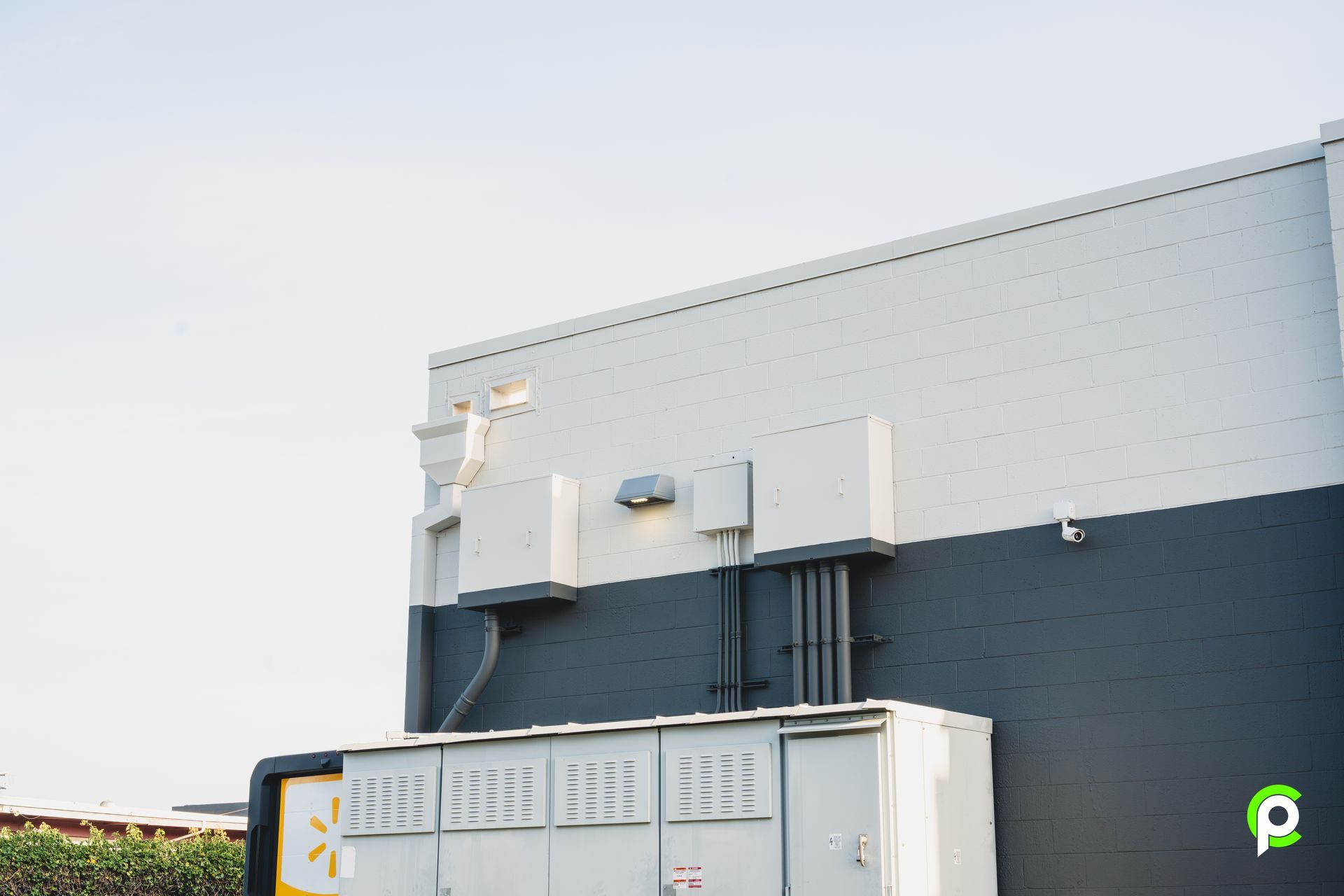 A black and white building with a large white box in front of it.