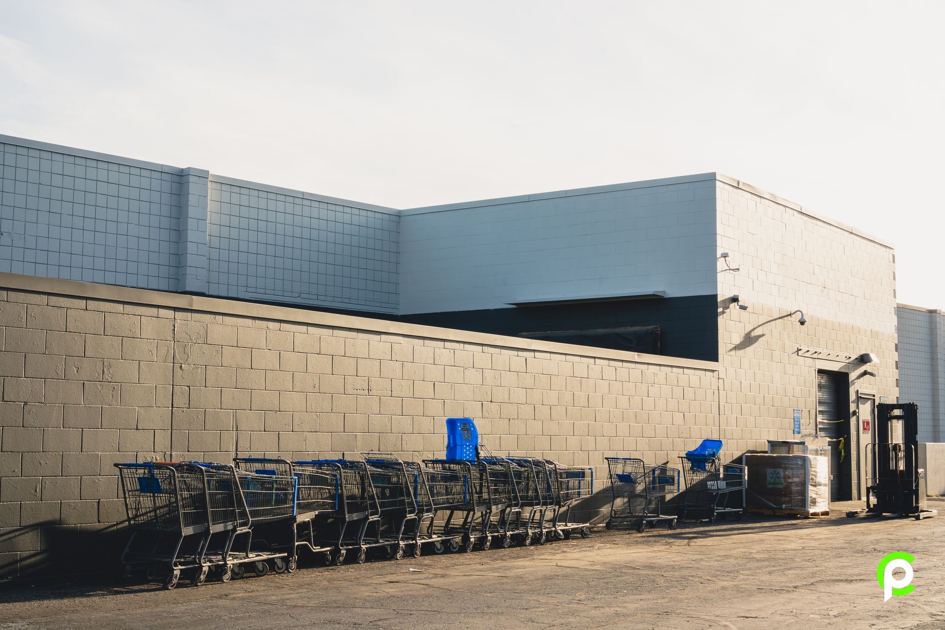A row of shopping carts are parked in front of a building.
