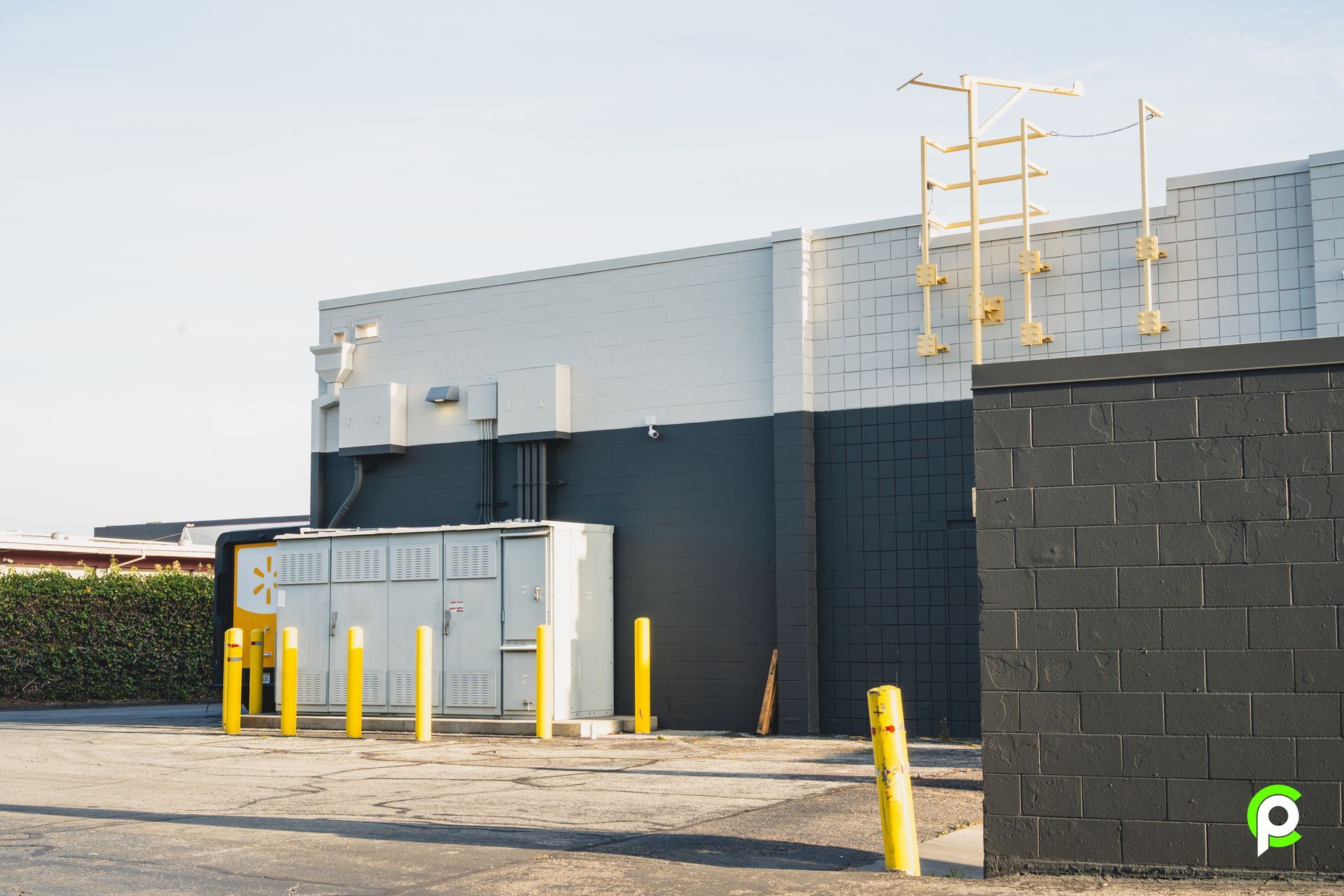 A black and white building with a yellow pole in front of it.