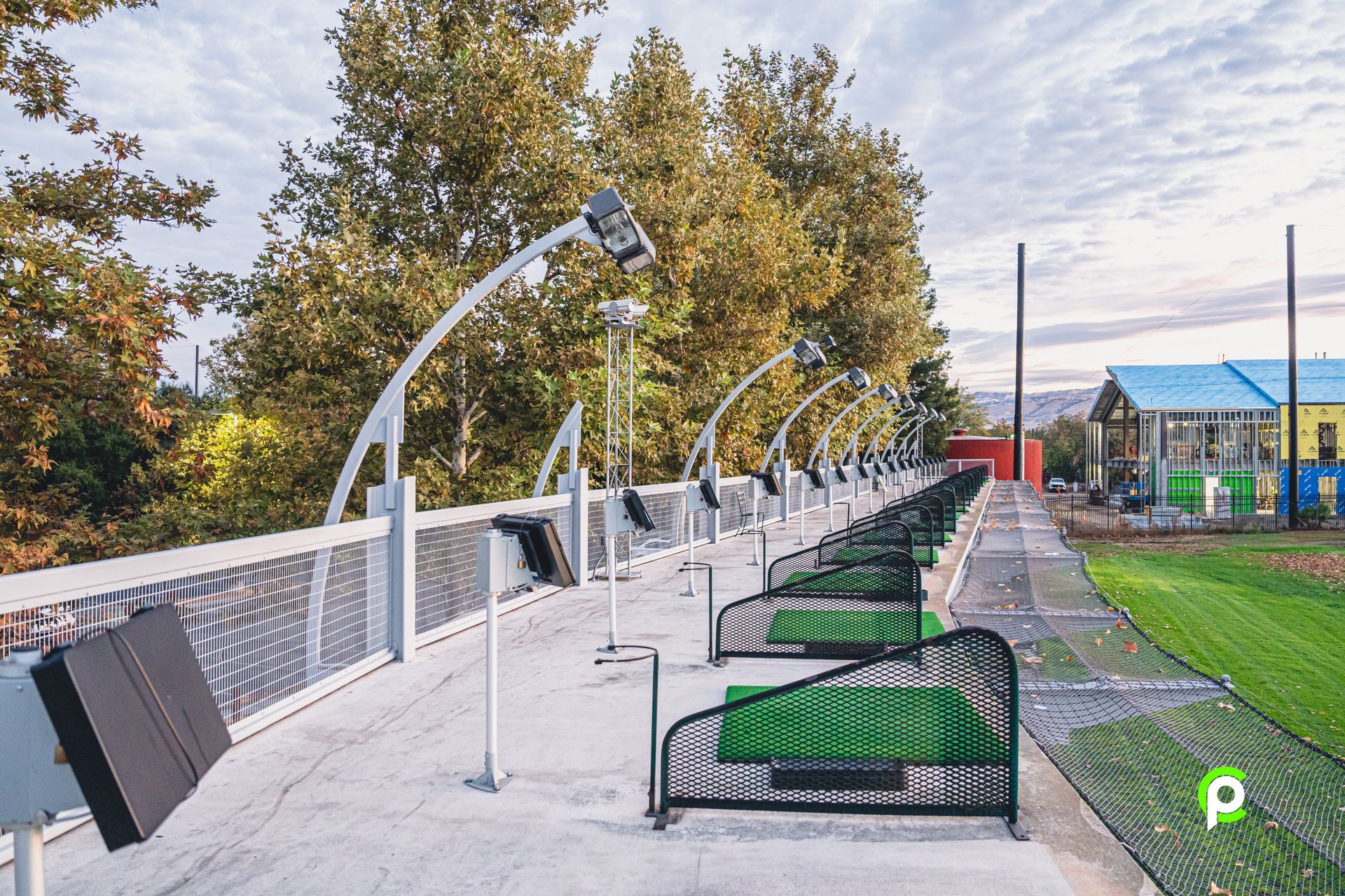 A row of benches on a sidewalk next to a bridge.