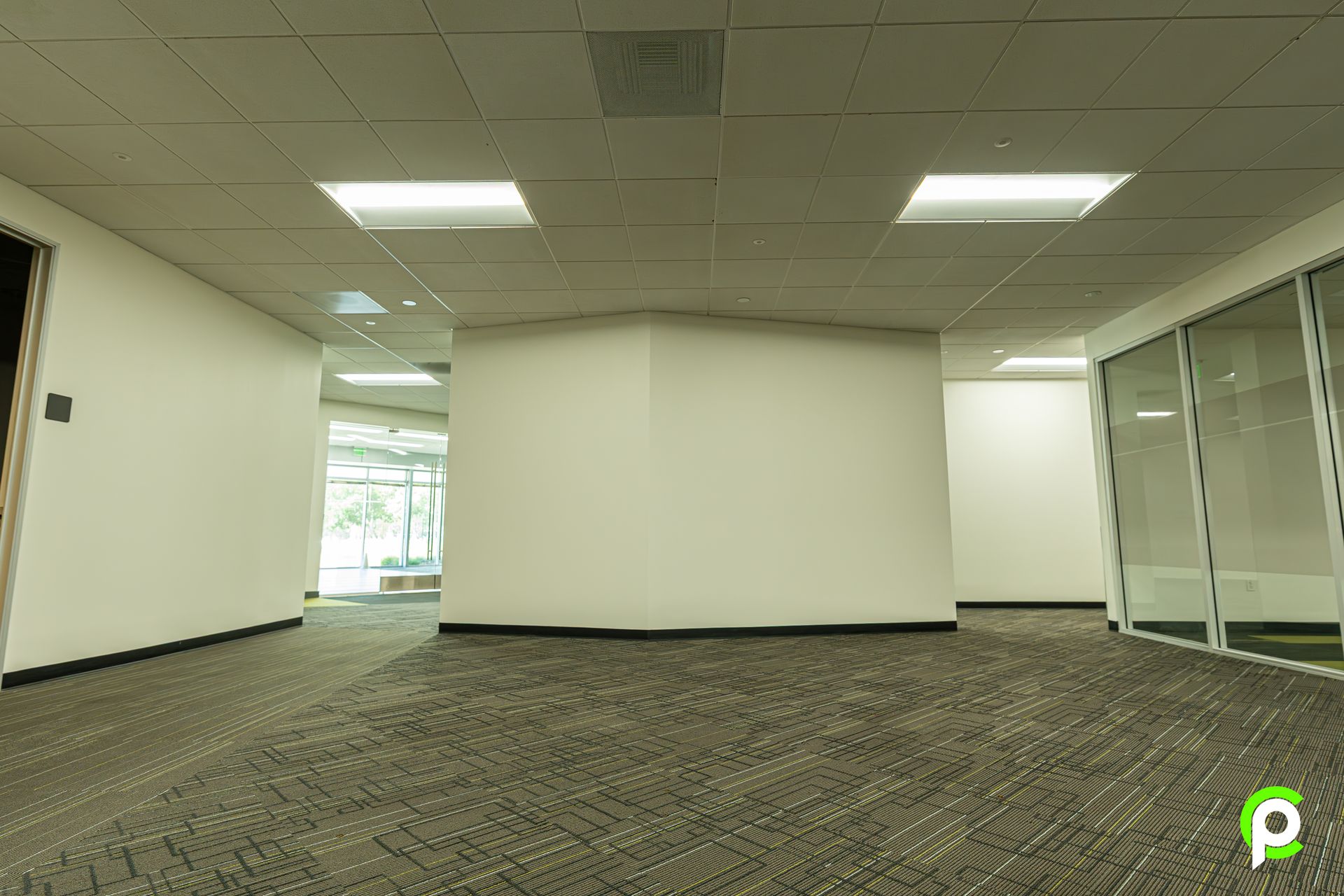 A large empty room with a carpeted floor and white walls.