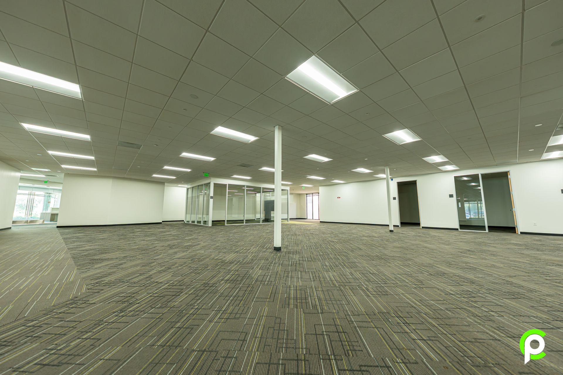 A large empty office building with a carpeted floor and white walls.